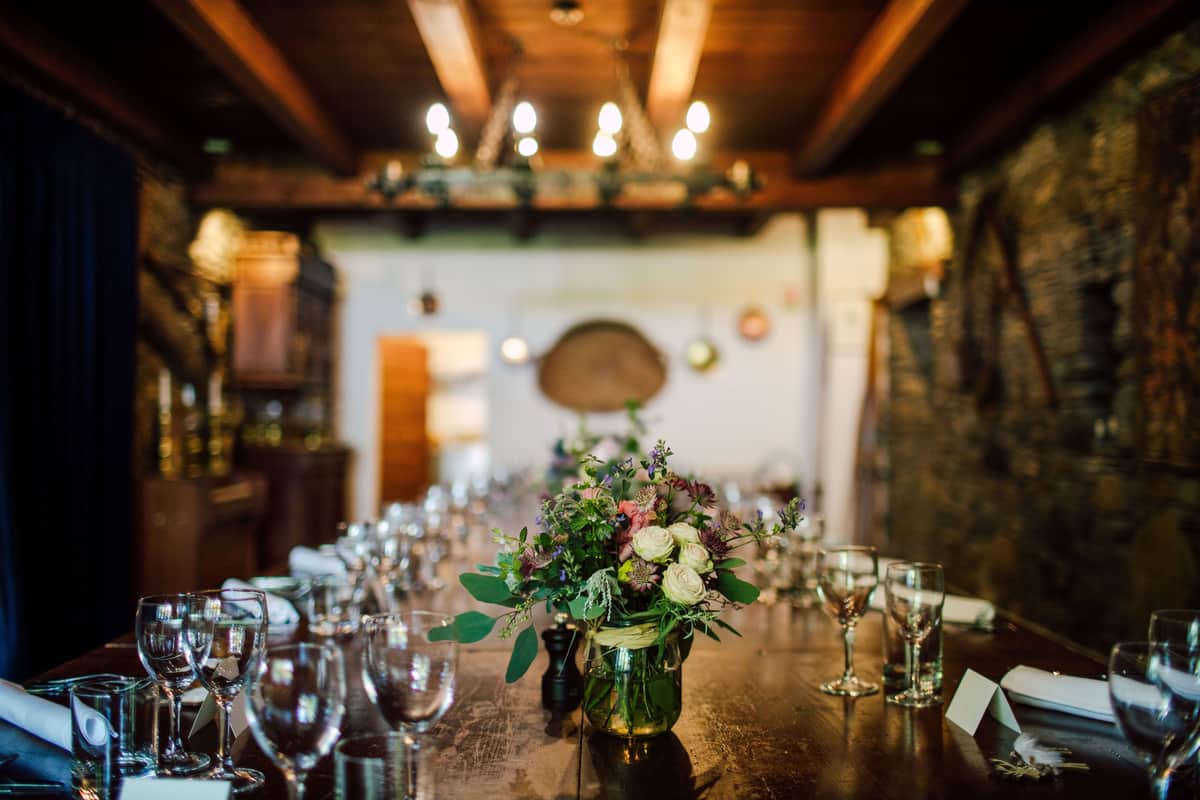 Table set with glasses and flowers in the beamed dining room