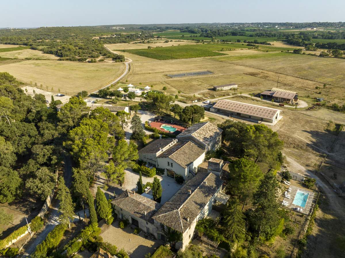 Aerial view of the estate hamlet with its swimming pool and white event marquees among the trees.