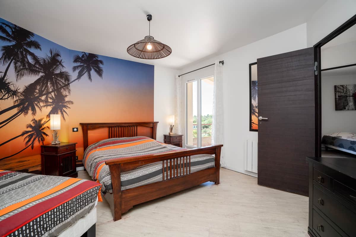 A bedroom with a wooden double bed and a second bed.