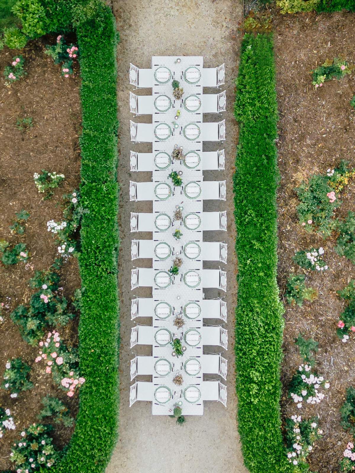Aerial view of a long reception table set symmetrically in the garden