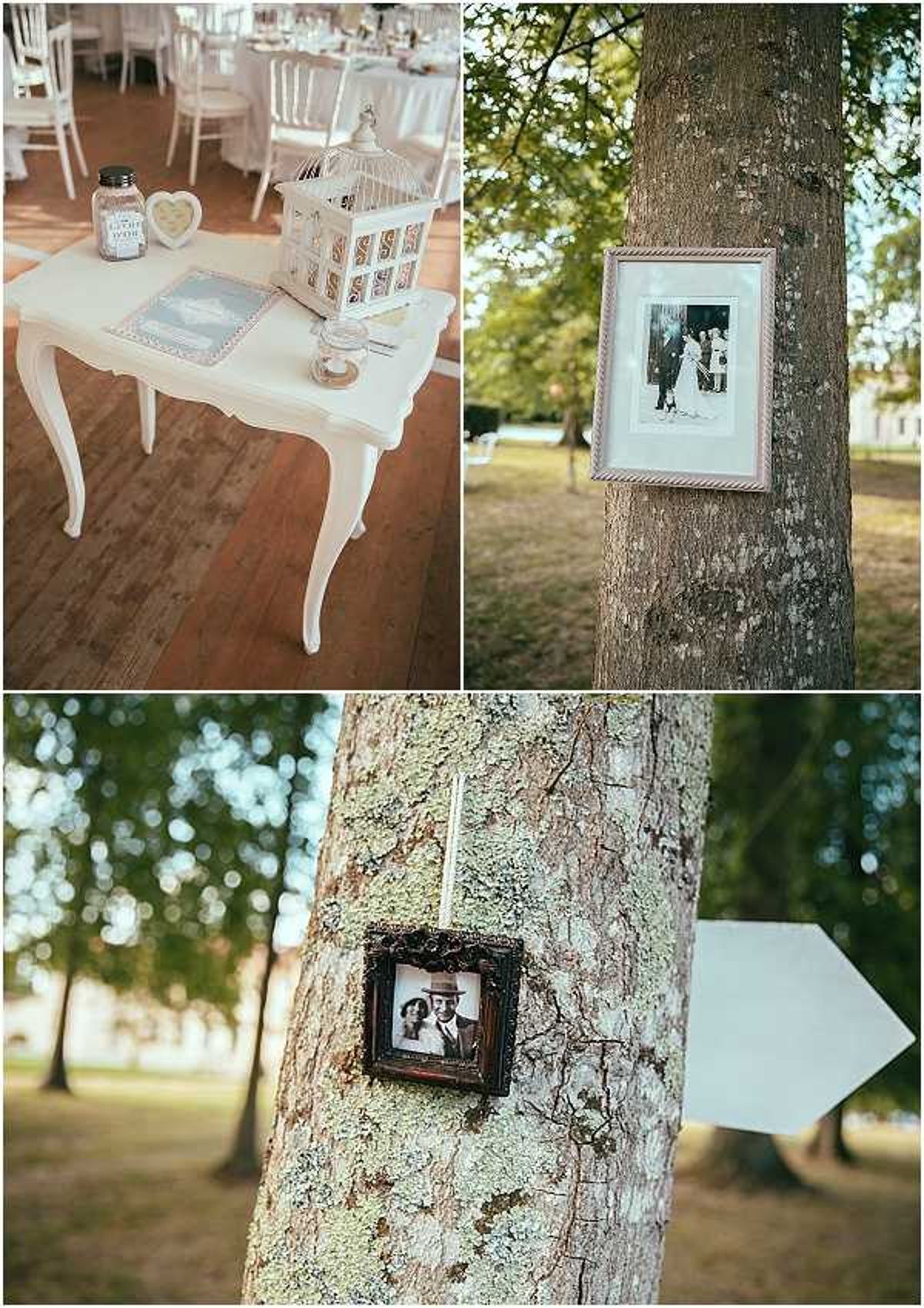 A three-image collage showing decorative details from an outdoor French wedding reception with a vintage, romantic styling theme. The top-left image shows a white ornate French-style table used as a welcome or gift table, holding a white decorative birdcage, a heart-shaped frame, a glass jar with a label, and a light blue guest book, with white Chiavari chairs and round tables set with white linens visible in the background marquee. The top-right image shows a close-up of a framed black-and-white vintage family photograph hung on a tree trunk, displayed in a pale pink or gold frame with white matting. The bottom image shows a second, smaller ornate dark-framed black-and-white vintage photograph of a couple hung on a tree trunk, alongside a white painted wooden directional arrow sign, part of an outdoor signage and memory-tribute display across the grounds. The overall decor palette is white, ivory, and pale gold with a vintage-inspired theme incorporating family heritage photos as decorative elements.