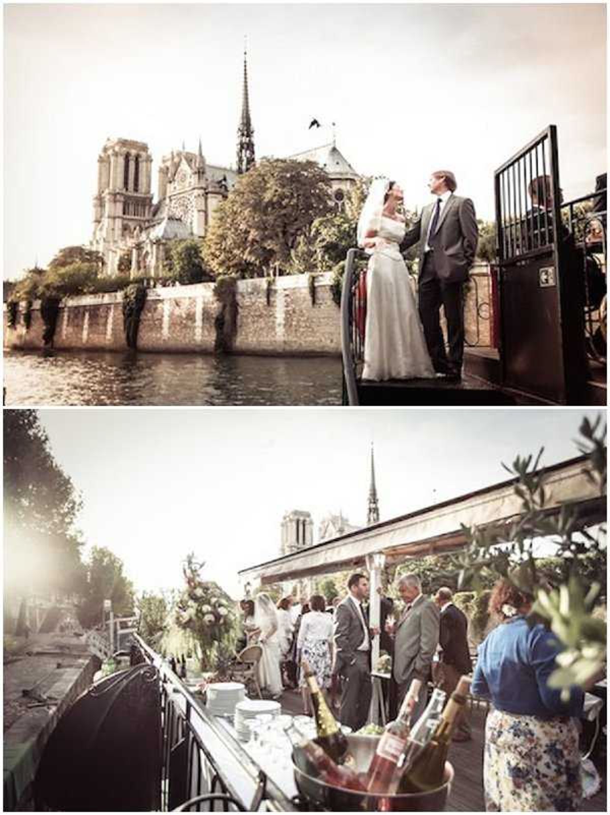 A two-image composite showing a wedding reception held on a boat on the Seine River in Paris, with Notre-Dame Cathedral clearly visible in the background of both shots. In the top image, the bride and groom stand together on the deck of the boat; the bride wears a white satin full-length gown and holds a white bouquet, while the groom wears a grey suit with a blue tie. The bottom image shows the cocktail hour scene on the boat's open deck, with approximately 15-20 guests mingling in semi-formal attire, a bar setup featuring champagne bottles in an ice bucket, and greenery arrangements decorating the railing. Both images have a warm, slightly faded tonal treatment with golden light suggesting late afternoon. Wide and medium shots are used across the two frames. Potential venue feature image.