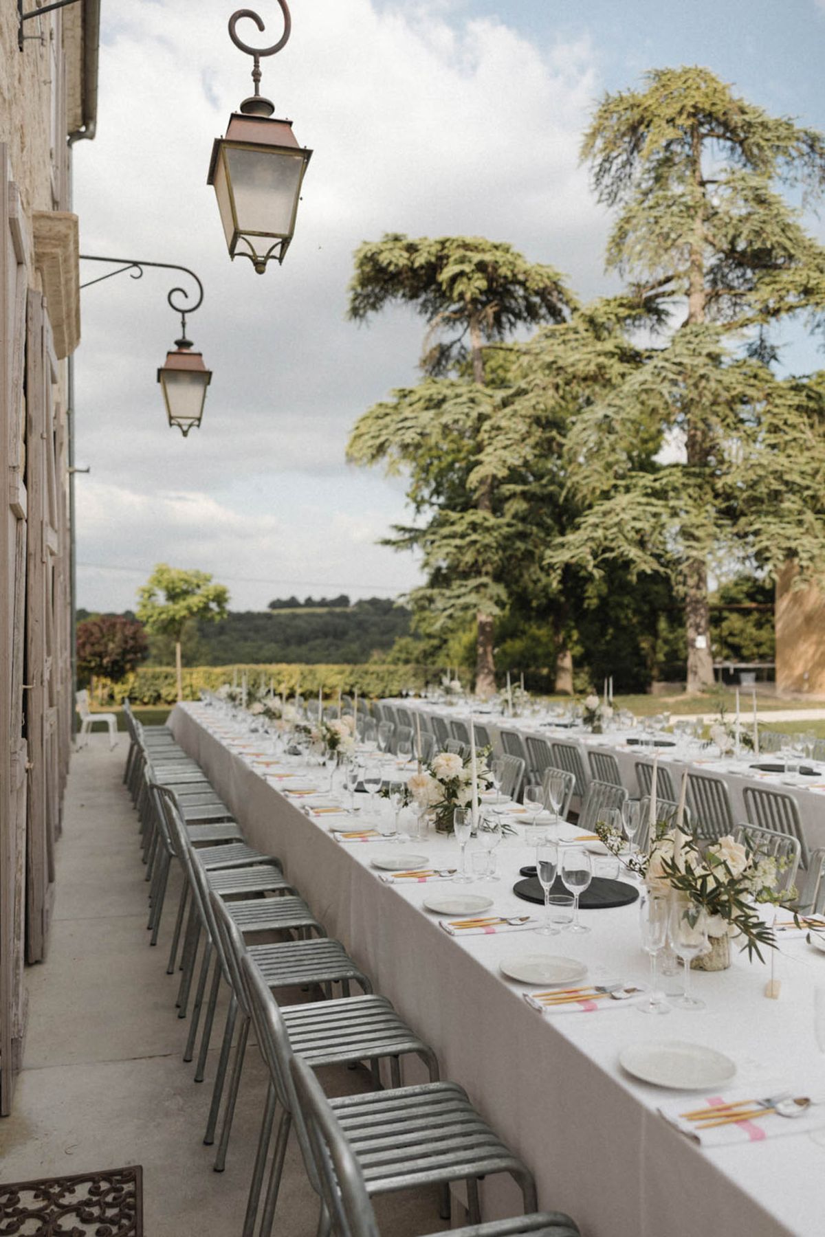 Terrace feasting table with sage bistro chairs white dahlia centerpieces colourful pencils and vineyard views