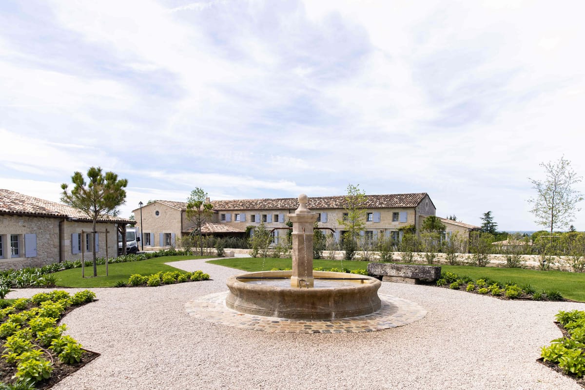 Honey limestone Provencal mas with stone fountain gravel courtyard blue shutters and box hedging