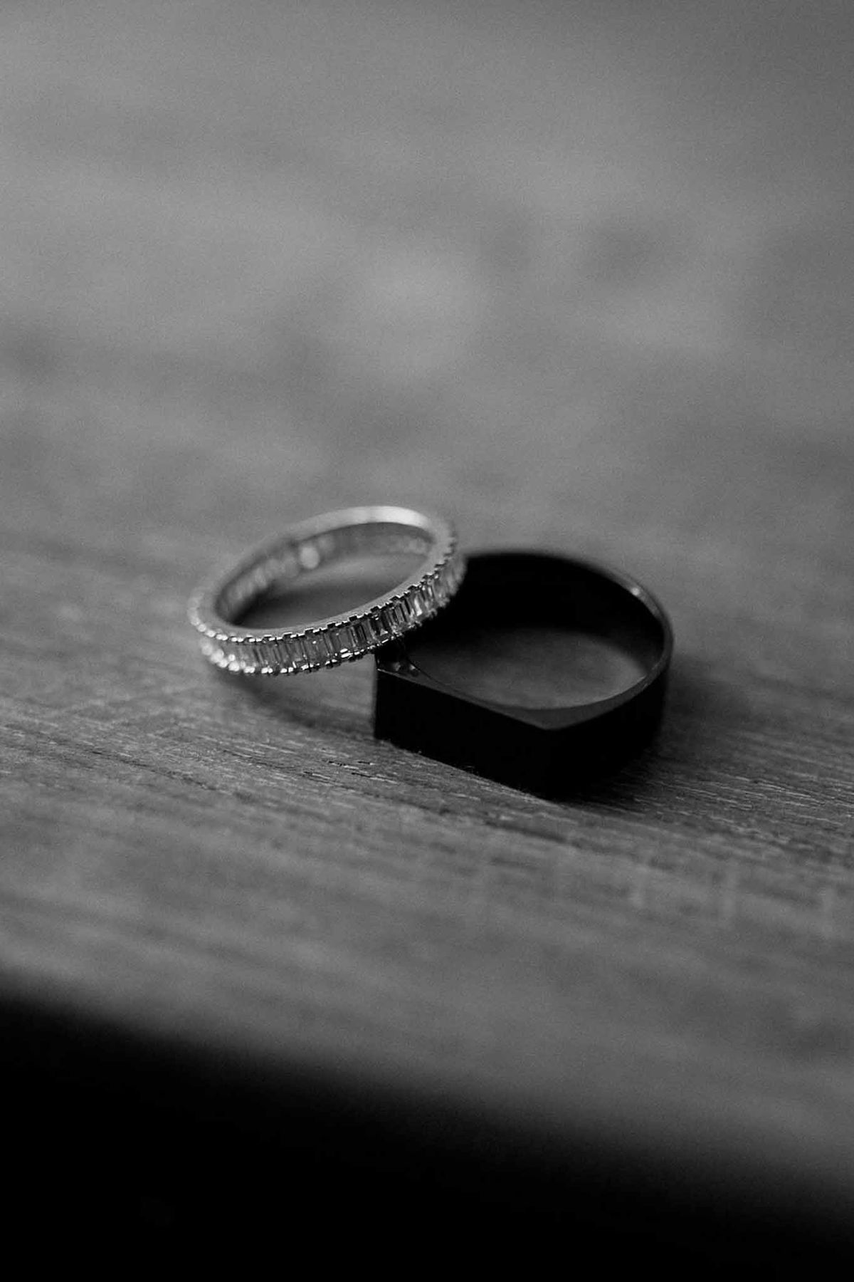 Diamond eternity band and black signet ring on wood in black and white at Château Sainte-Roseline
