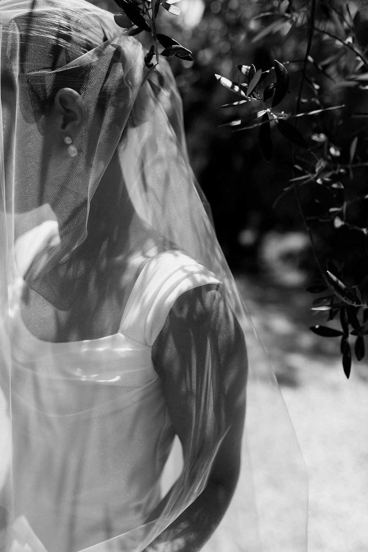 Bride's profile with veil and olive tree shadows in black and white at Château Sainte-Roseline