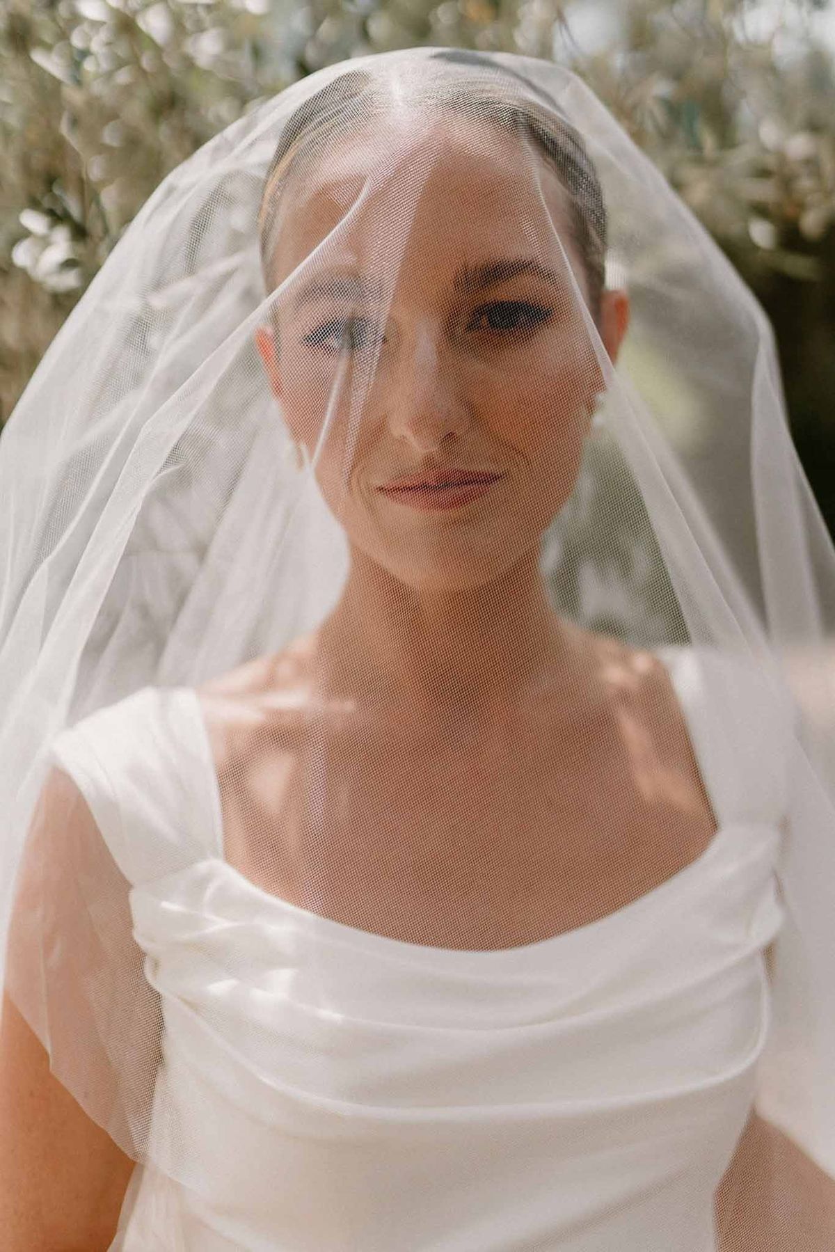 Bride looking through cathedral veil close-up at Château Sainte-Roseline