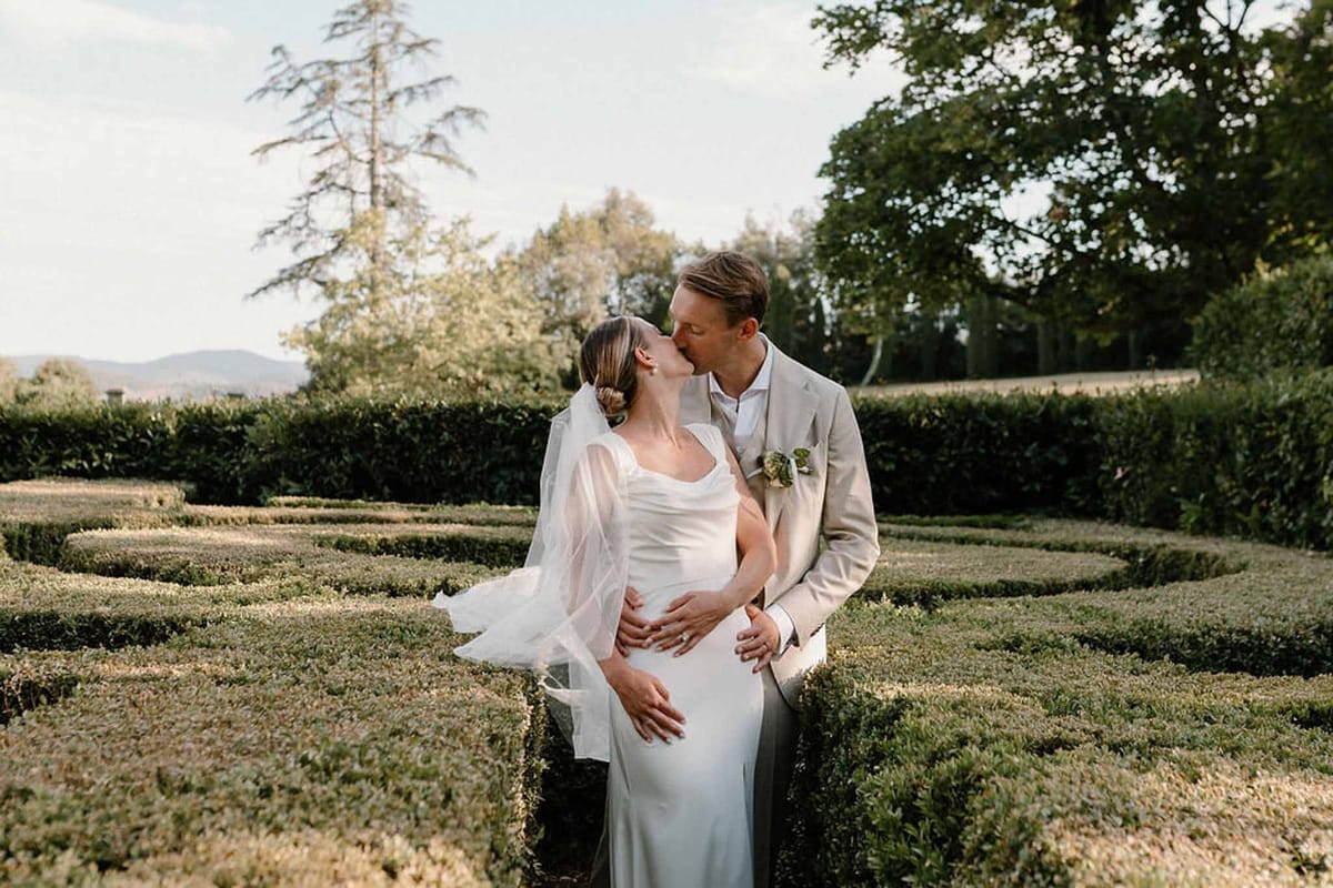 Couple kissing in formal box-hedged garden at Château Sainte-Roseline