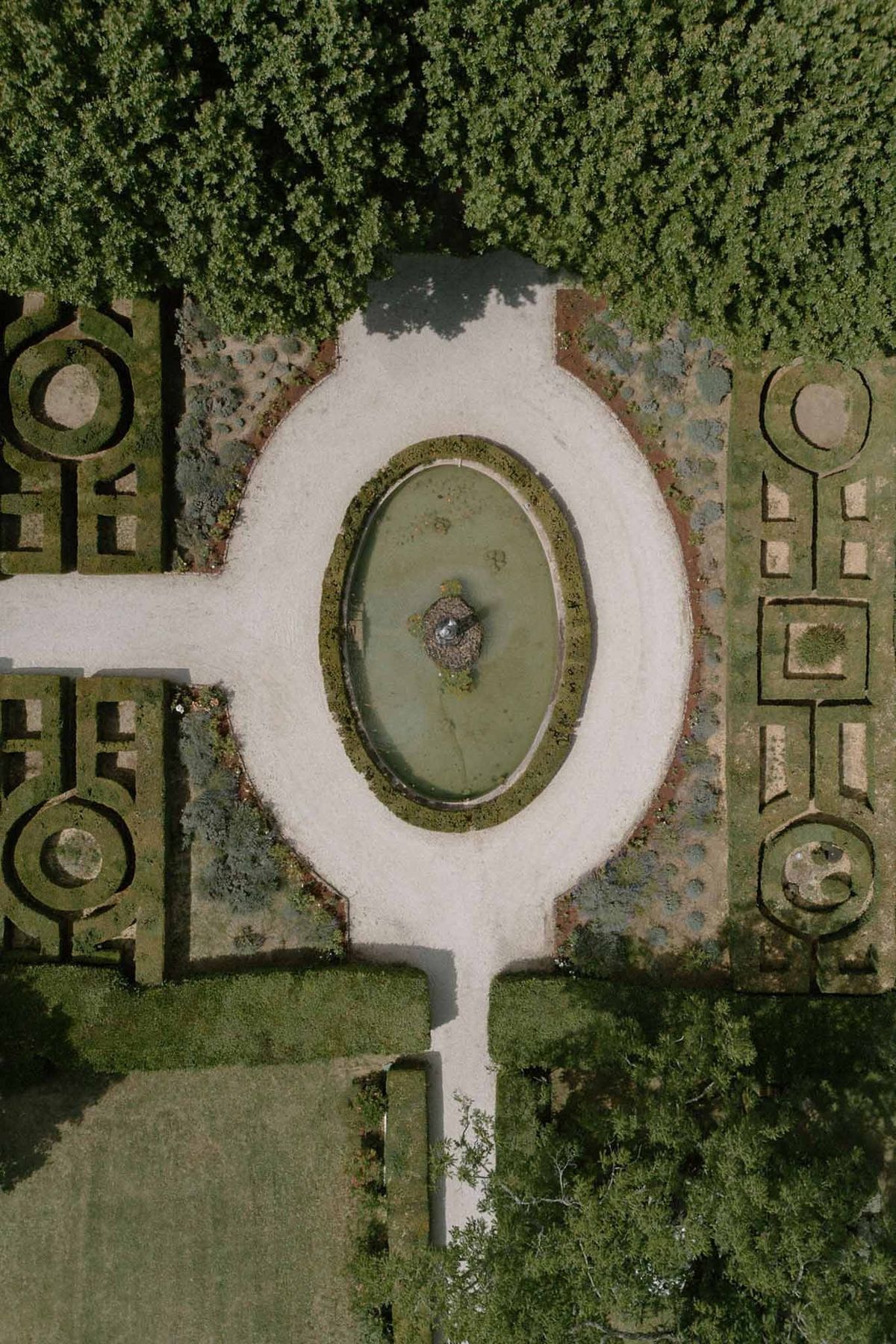 Drone view of formal parterre garden with oval fountain at Château Sainte-Roseline