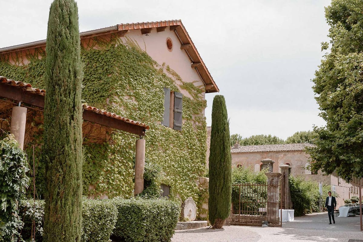 Ivy-covered entrance with cypress trees at Château Sainte-Roseline