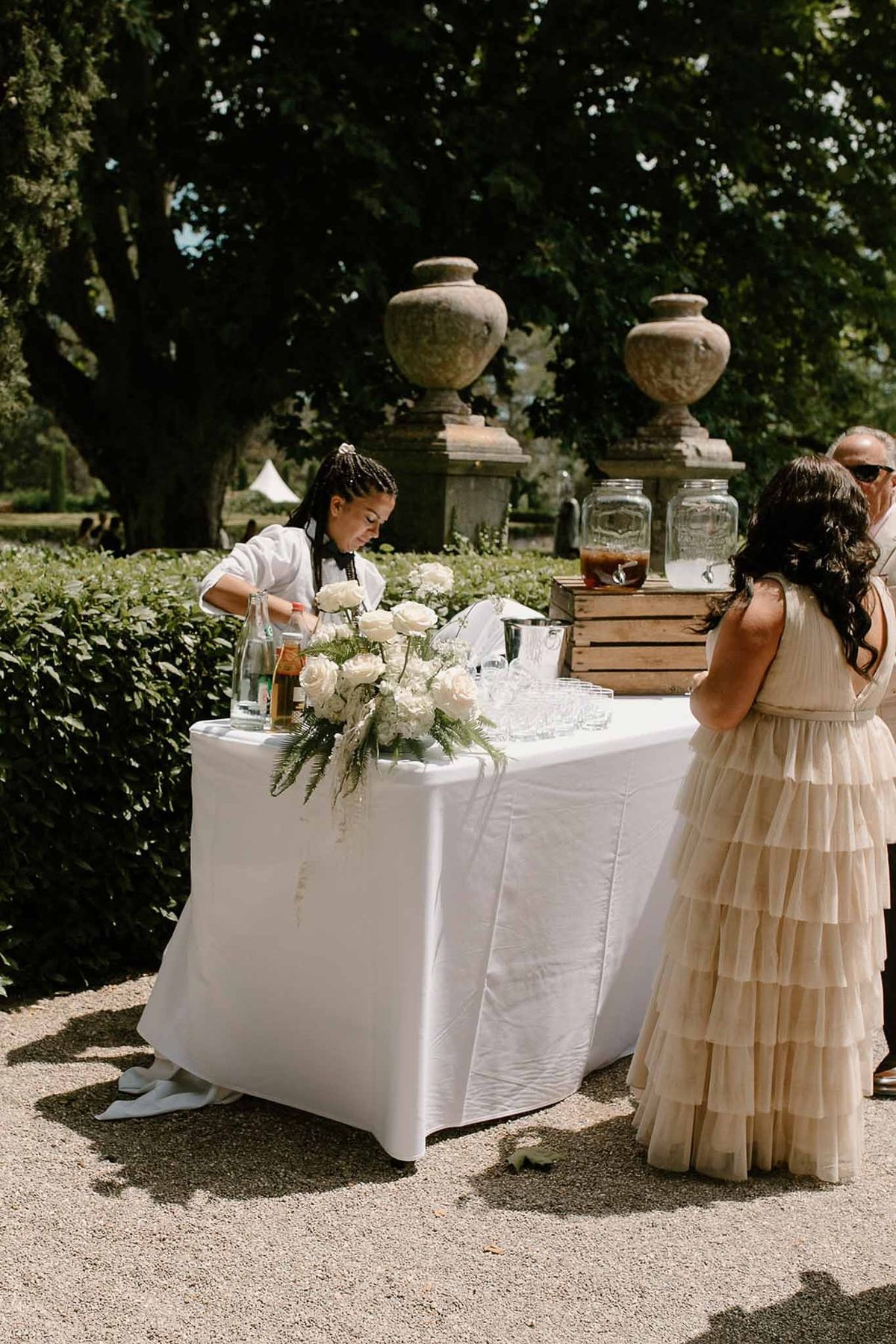 Cocktail bar with white rose arrangements in garden at Château Sainte-Roseline