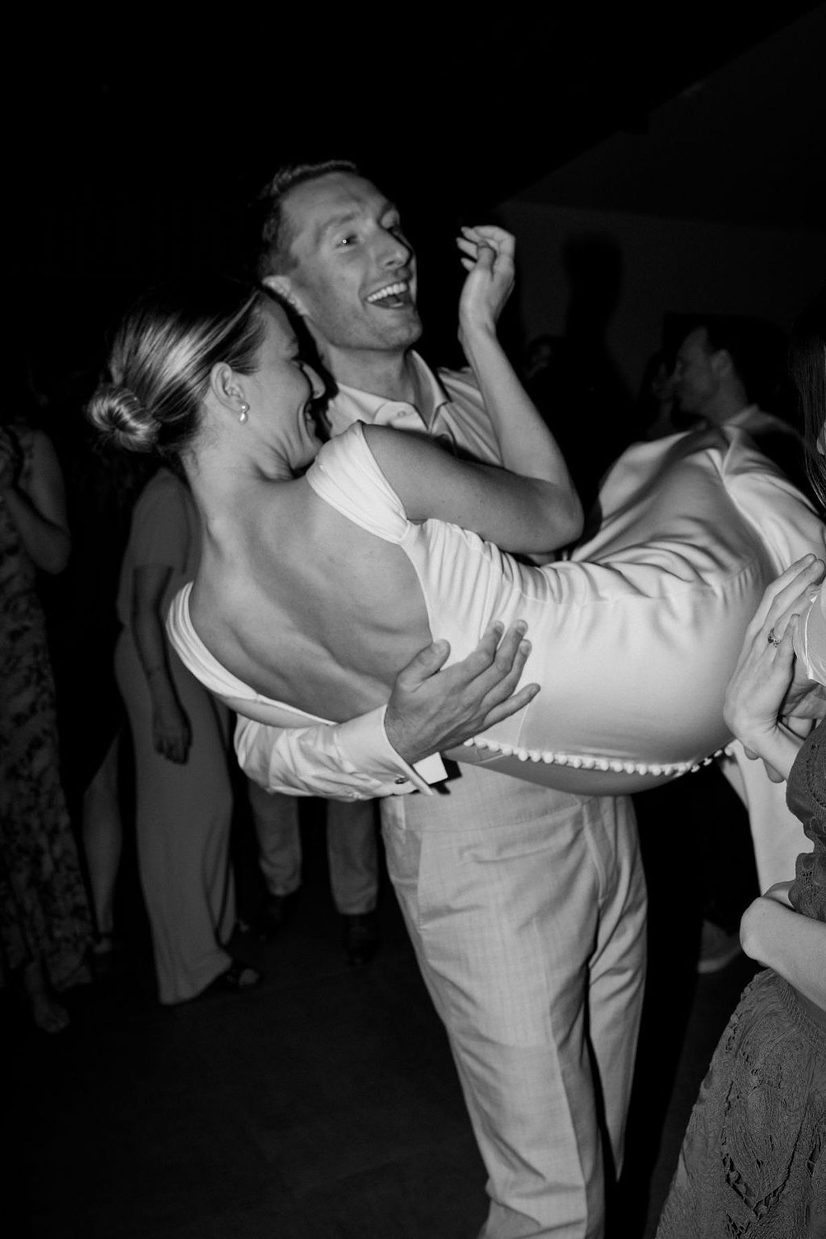 Groom lifting laughing bride on the dance floor in black and white at Château Sainte-Roseline