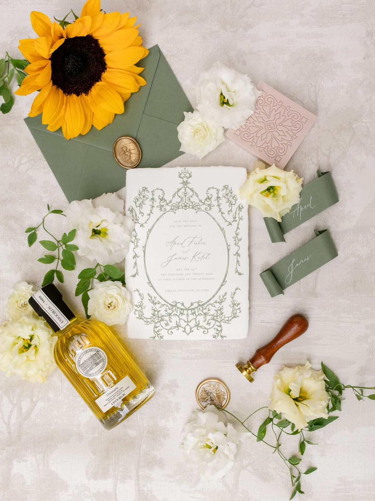 Stationery flat lay with sage envelope gold wax seal calligraphy cards olive oil and sunflower