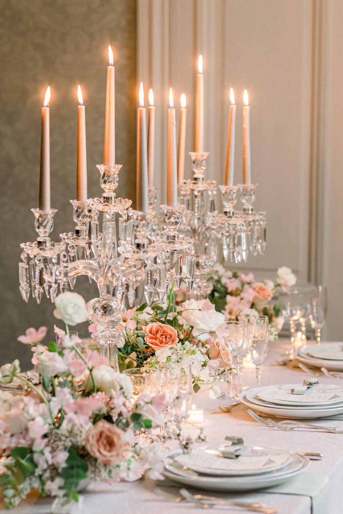 Reception table with blush floral garland, crystal candelabras, and pink linen in panelled room