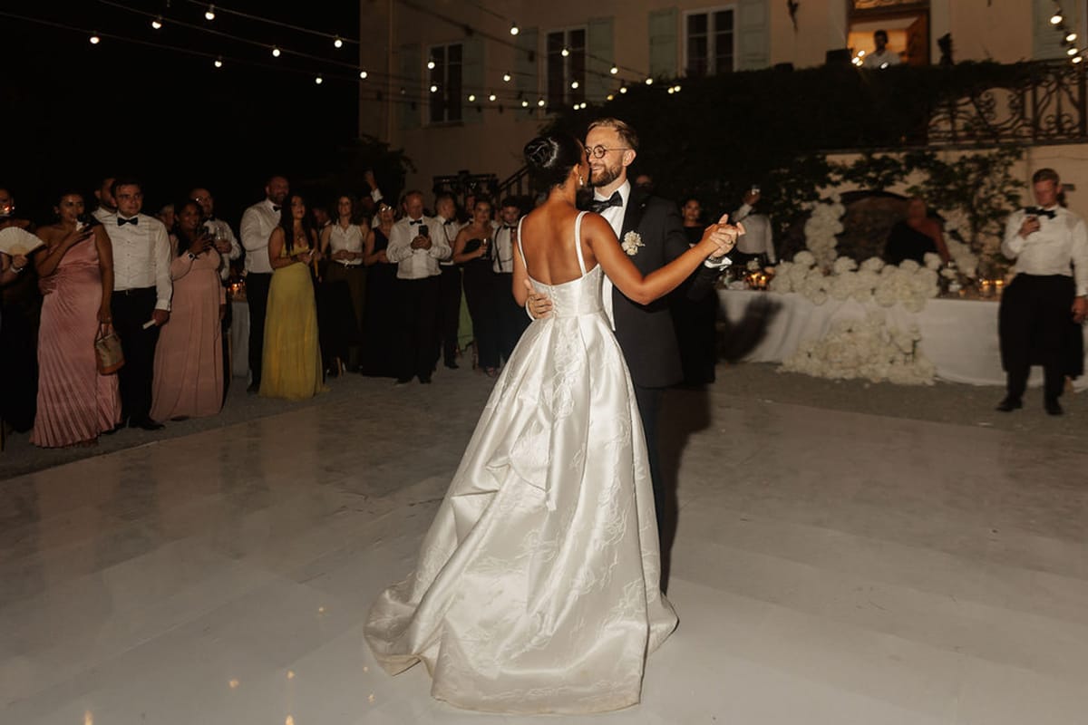 First dance at outdoor courtyard reception with string lights and candlelit tables