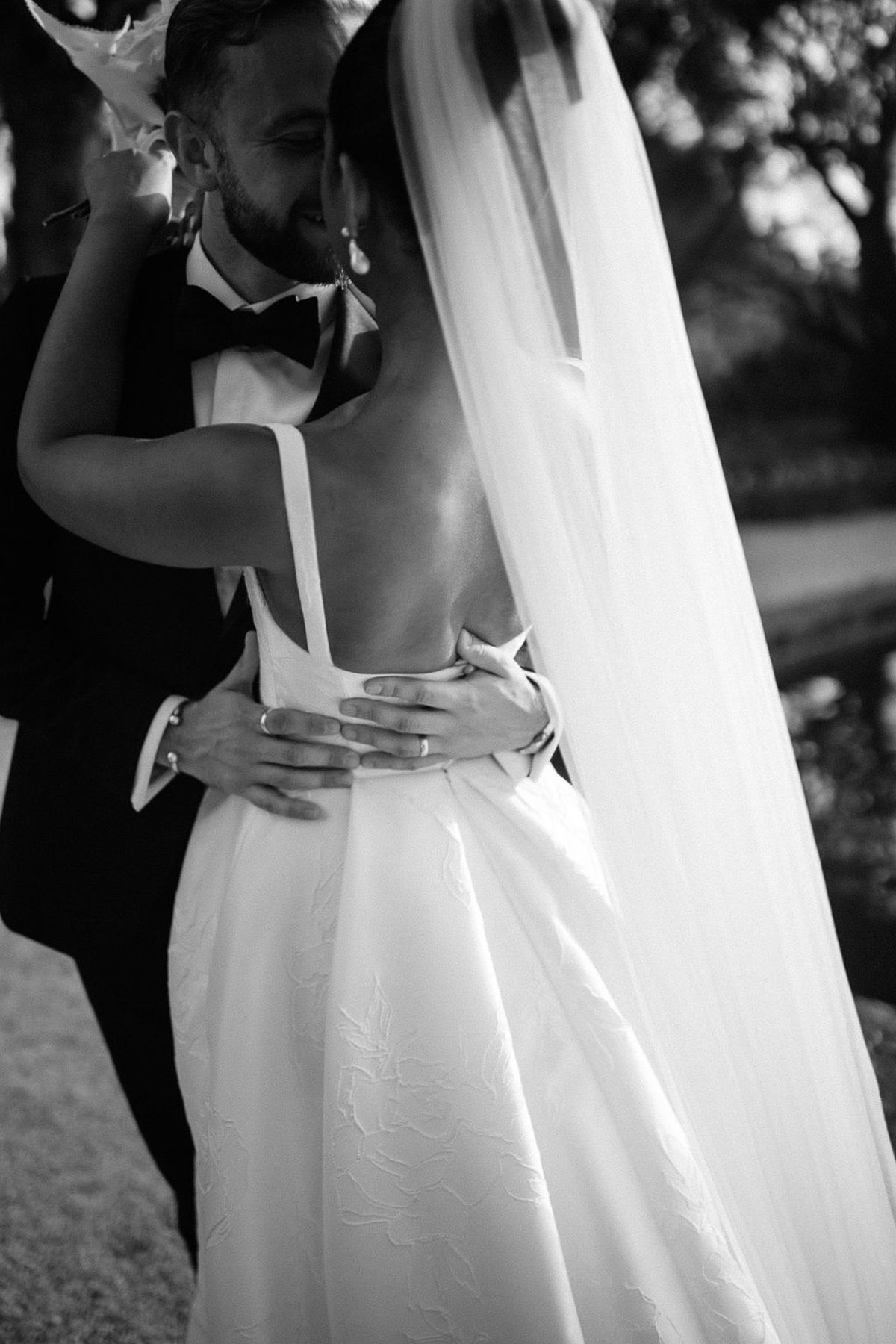 Bride and groom embracing during first dance in outdoor garden setting