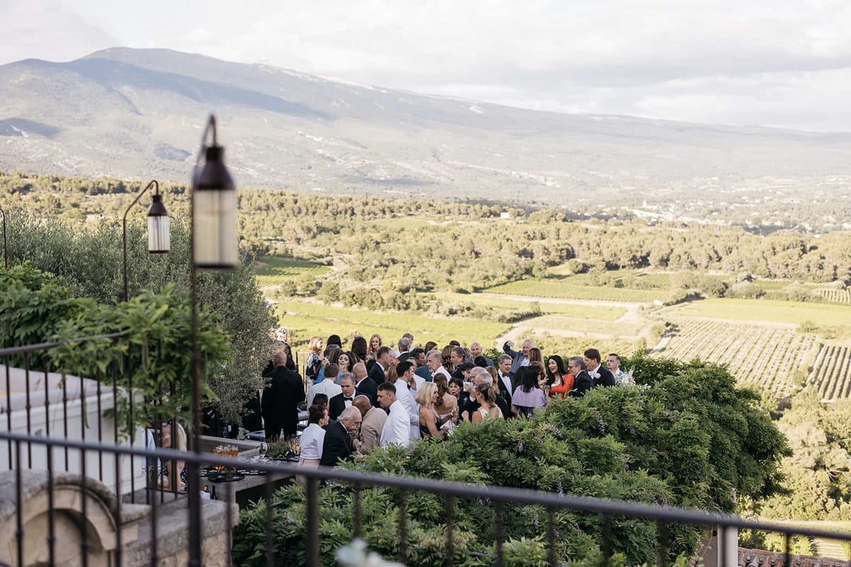 Cocktail hour gathering on vineyard terrace with panoramic landscape views
