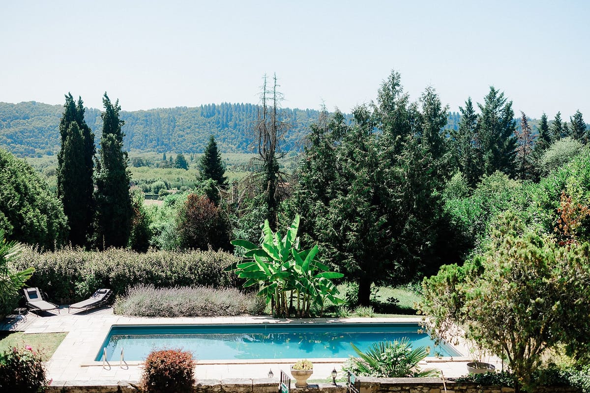 Swimming pool and hillside landscape at outdoor wedding venue with cypress trees and rolling countryside views