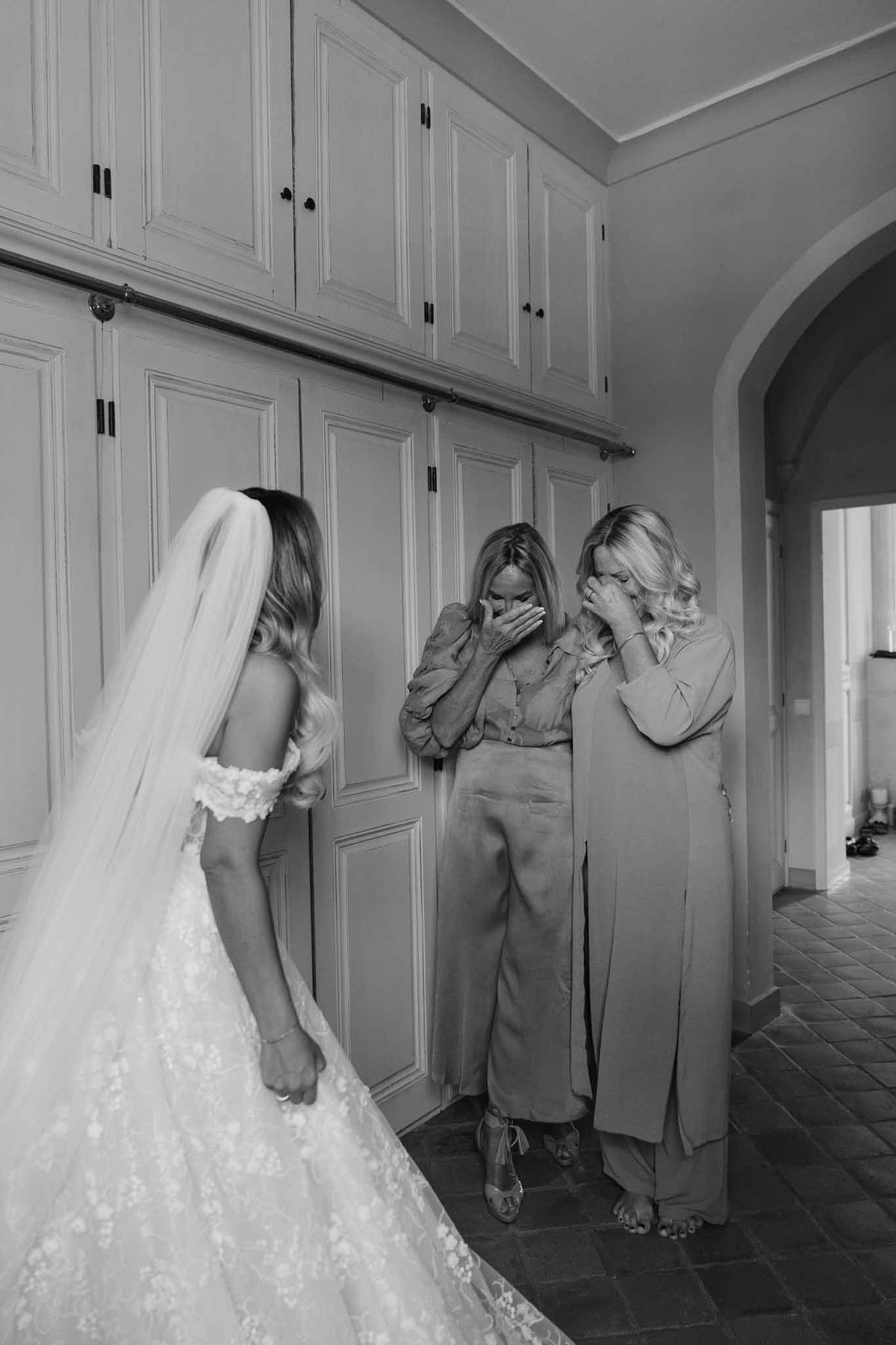 Bride revealing wedding dress to family members in modern dressing room