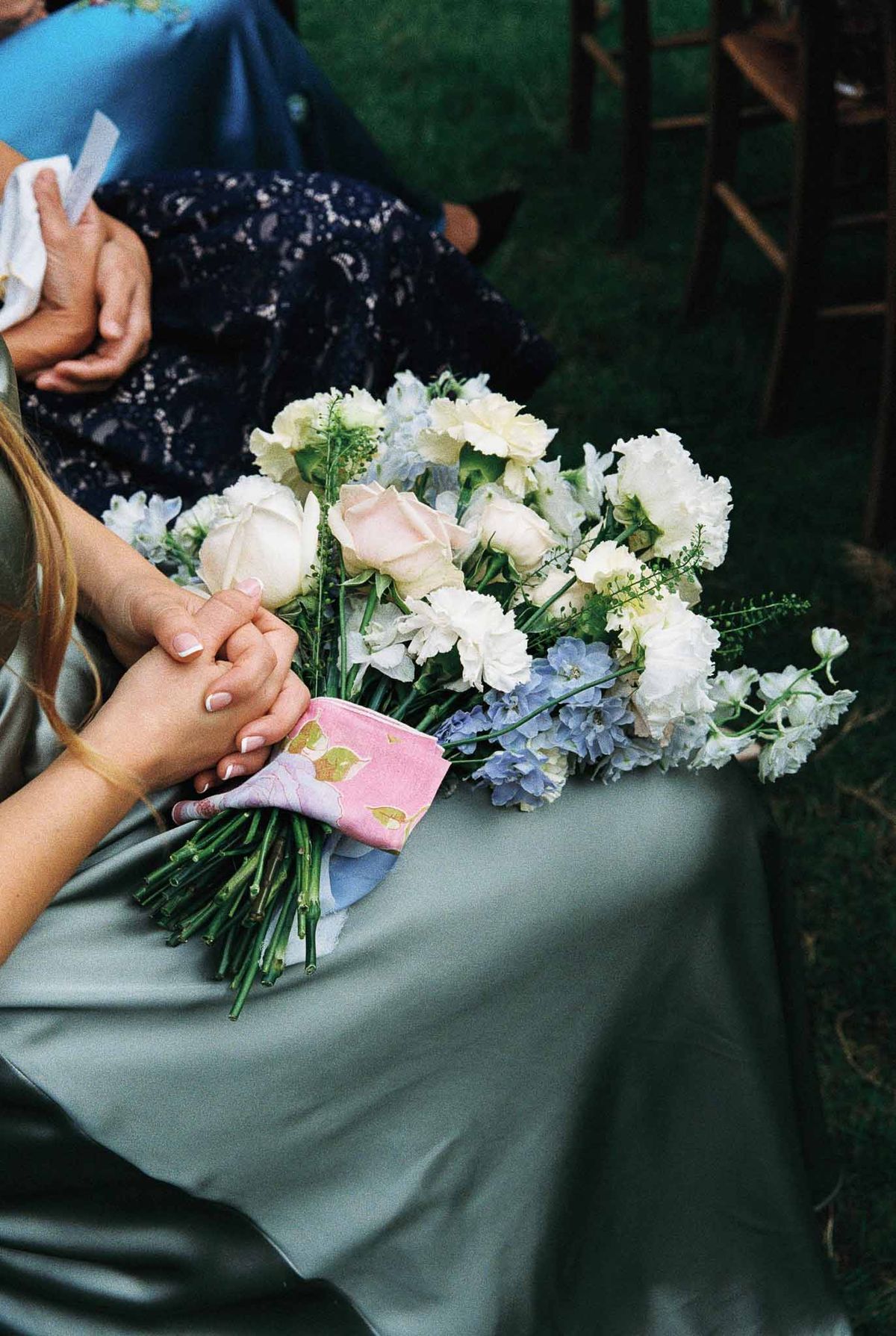 Bride holding ivory and blush bridal bouquet during outdoor garden ceremony
