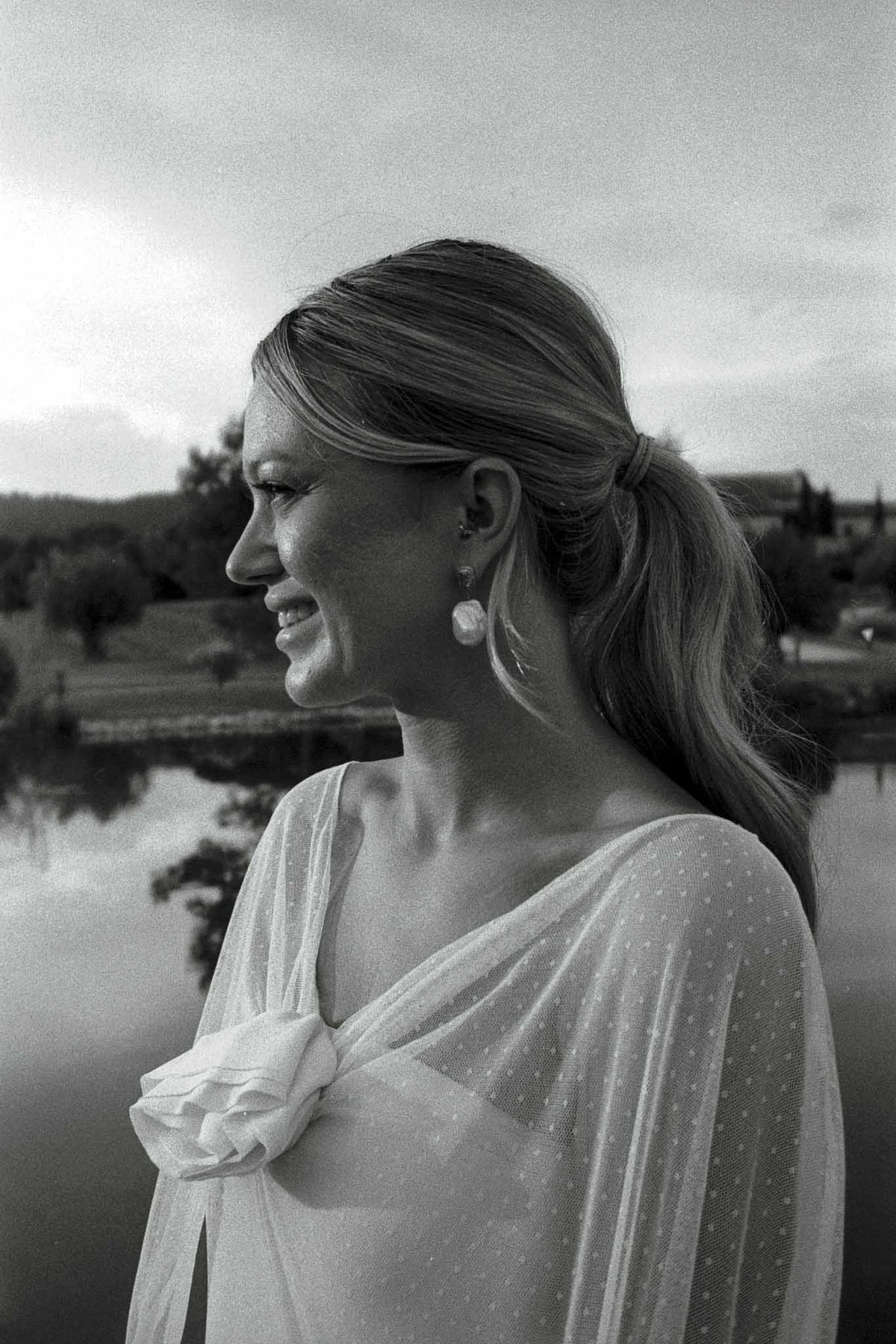 Bride in profile portrait with water backdrop at outdoor wedding venue
