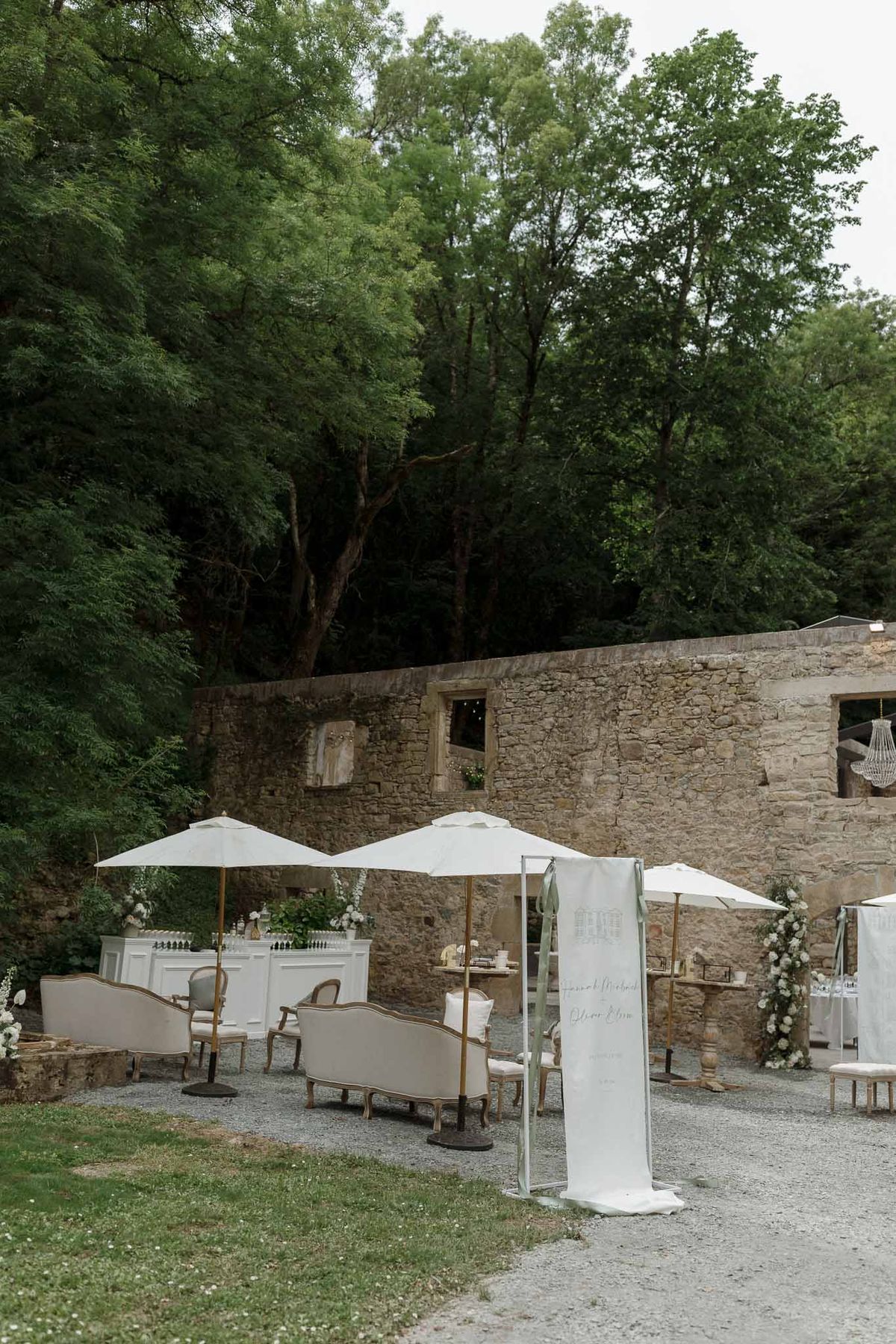 Cocktail lounge area with umbrellas and seating in stone courtyard at historic venue