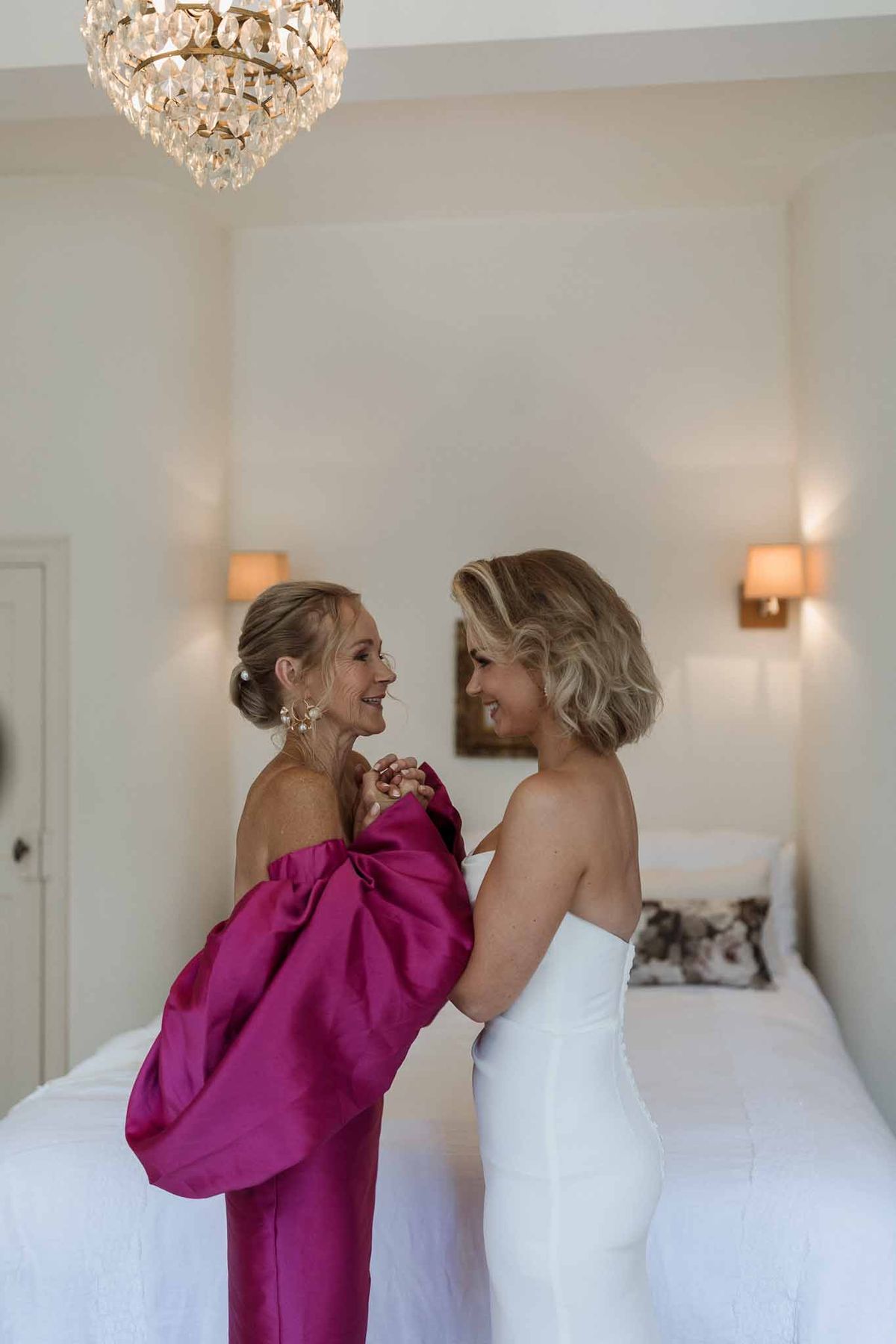 Bride and bridesmaid sharing moment during wedding preparations in elegant bridal suite