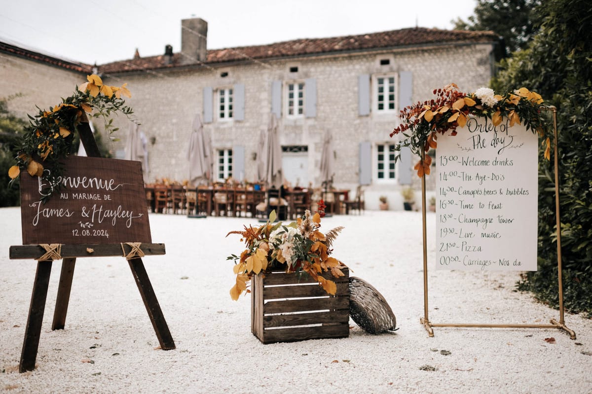 Autumn welcome display with amber floral crate, Bienvenue easel, and burgundy berry order of day sign