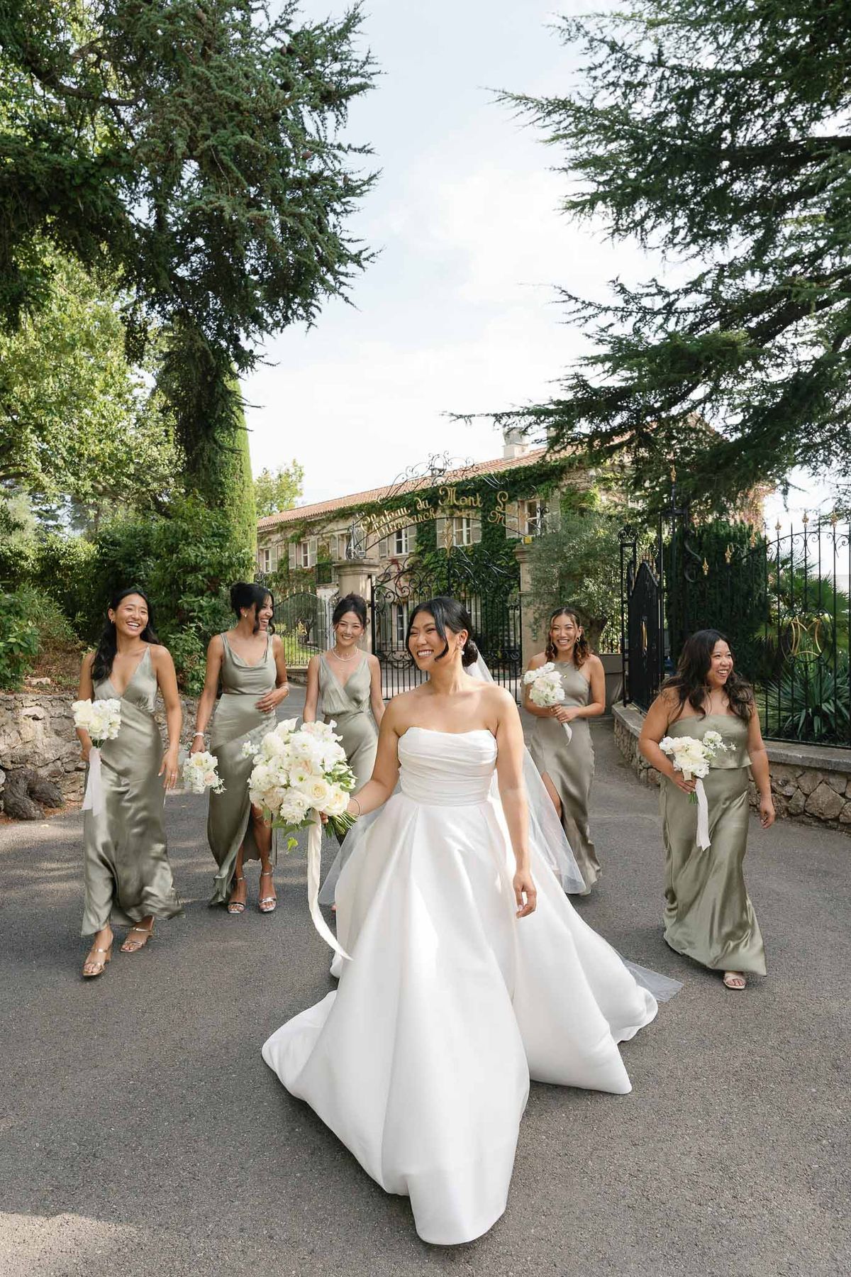 Bride and bridesmaids walking along stone pathway at Mediterranean villa