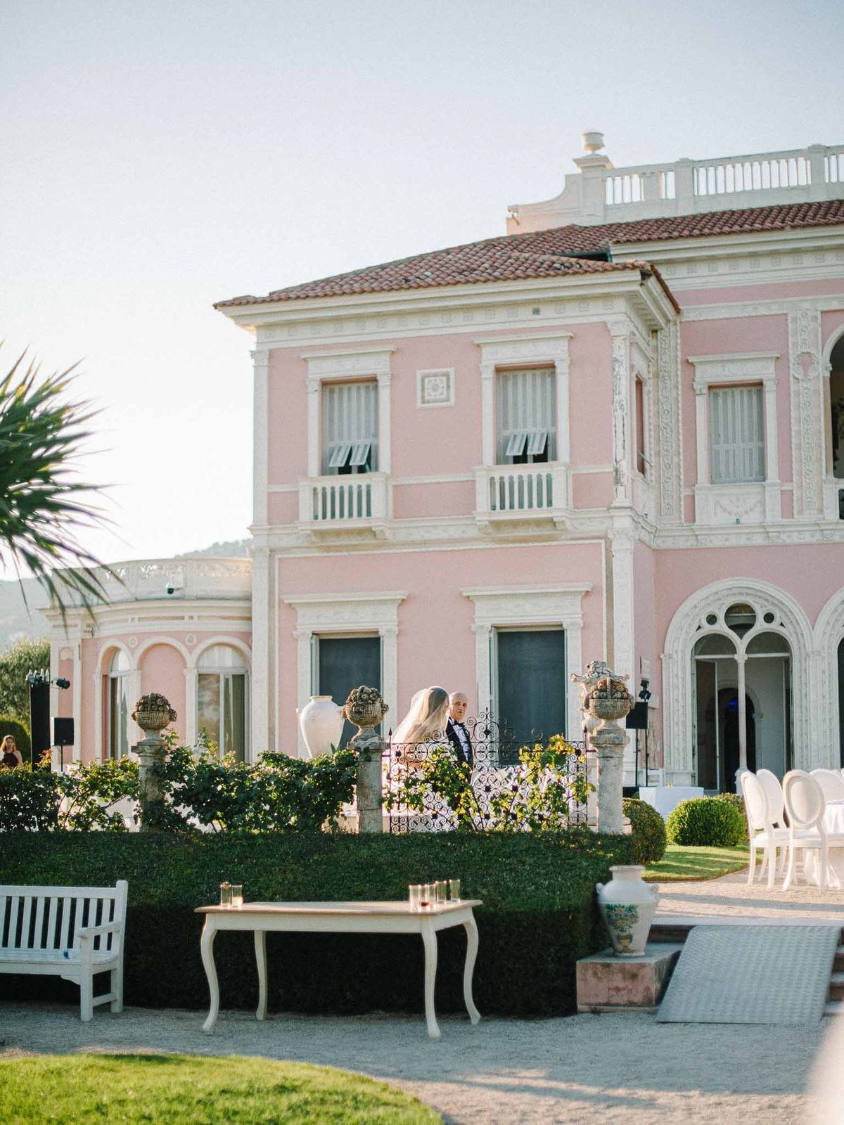 Neoclassical villa wedding venue with courtyard reception setup and guests mingling at elegant outdoor celebration