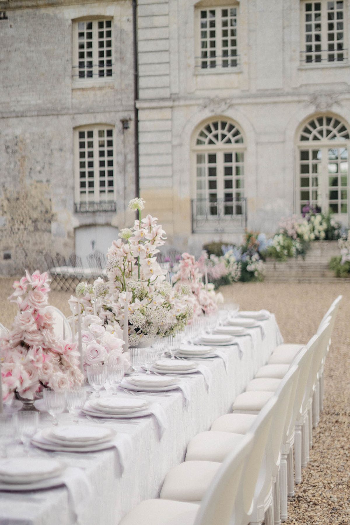 White reception table with blush florals in historic stone courtyard venue