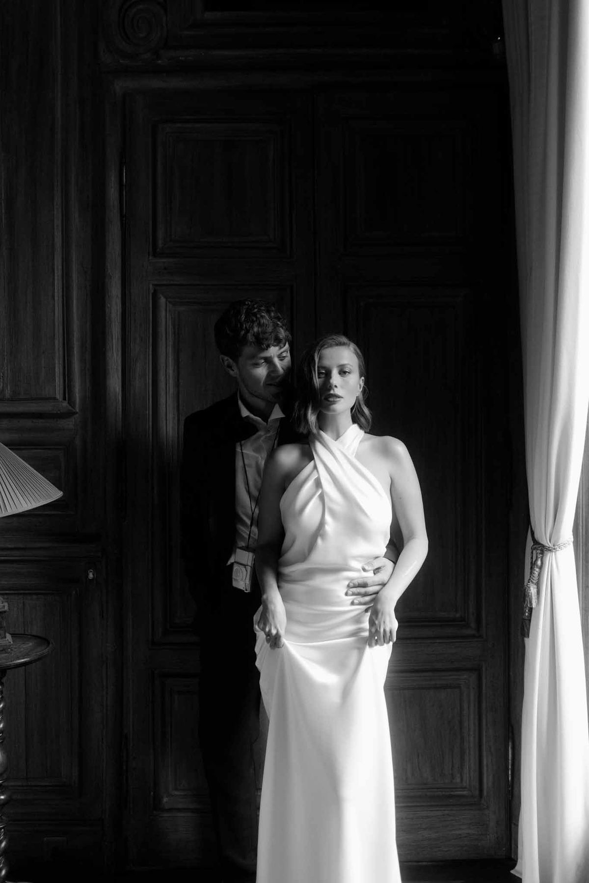 Black and white bride and groom portrait against wooden door in historic interior