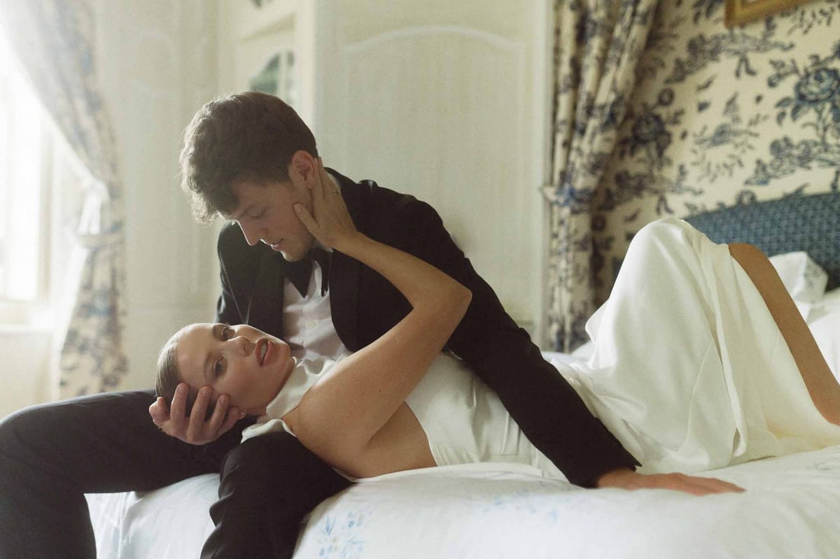 Intimate bride and groom portrait in bedroom during wedding preparations