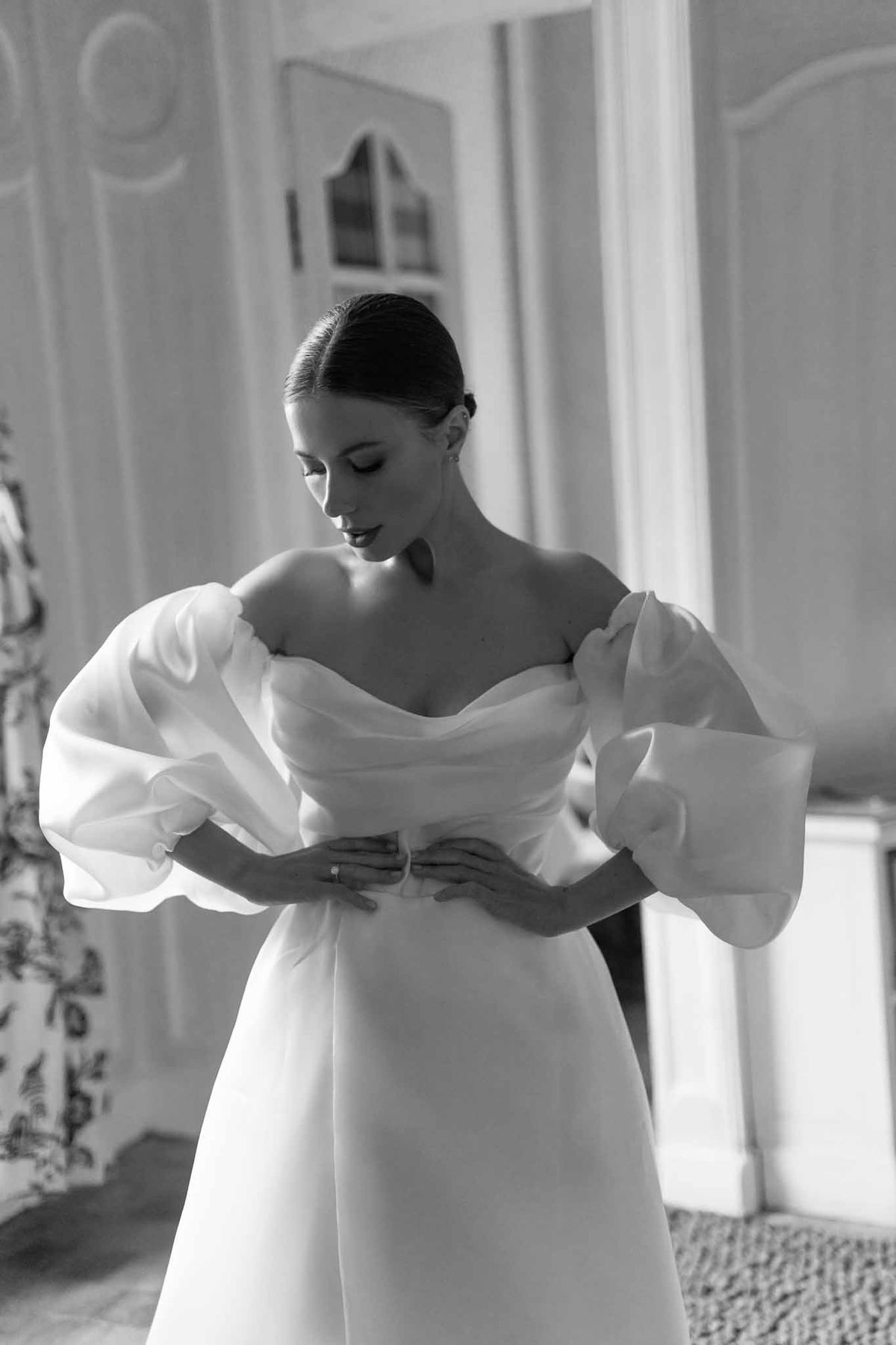 Bride reading letter in minimalist bridal suite with architectural details