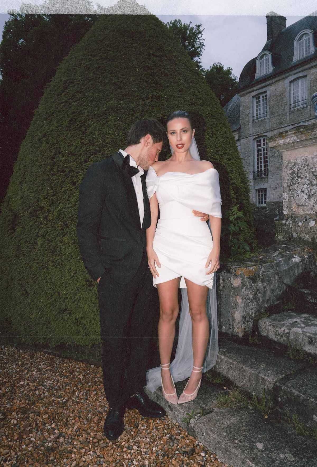 Bride and groom formal portrait in manicured garden at stone château venue