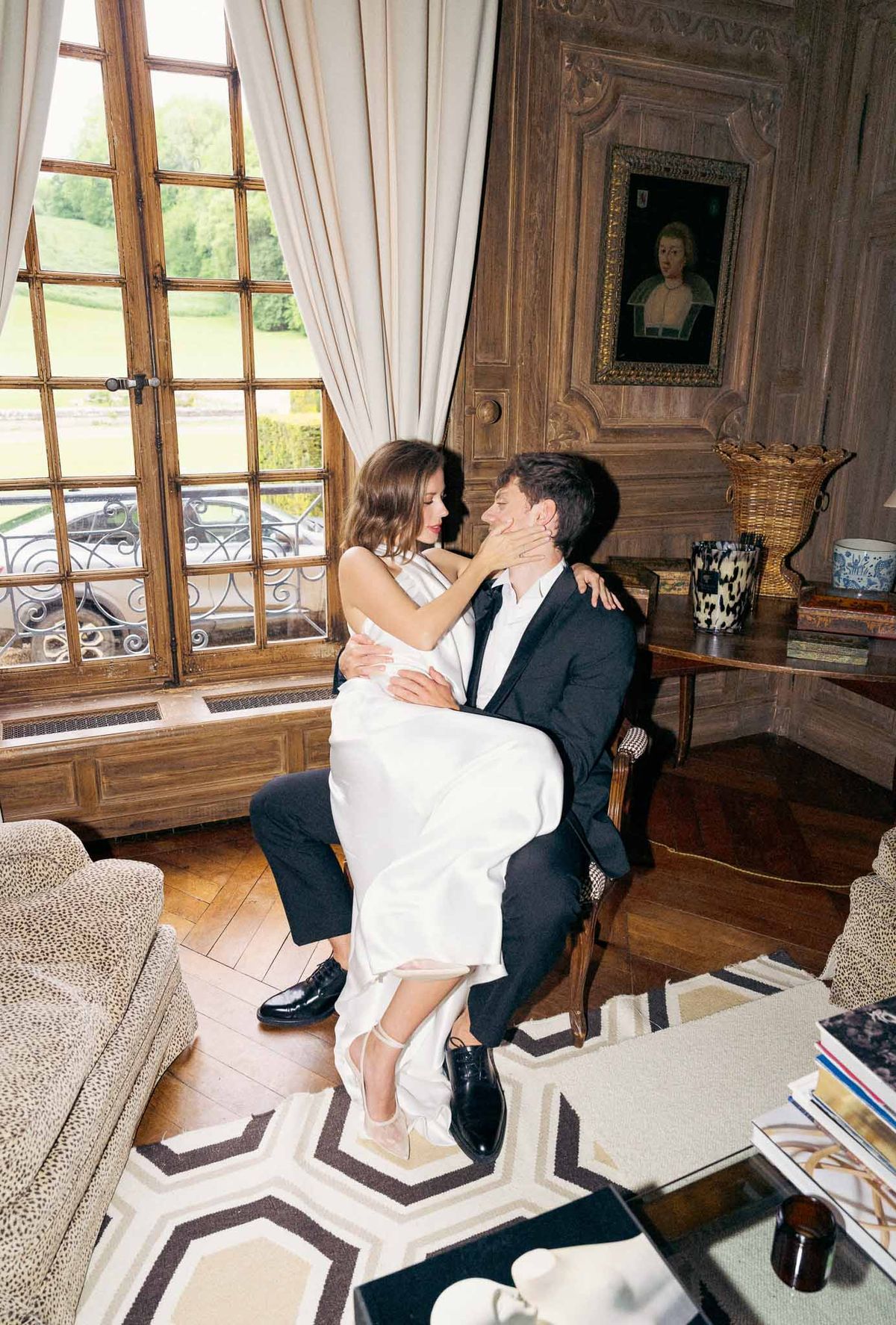 Intimate couple portrait in classical salon with wooden paneling and antique furnishings at historic château