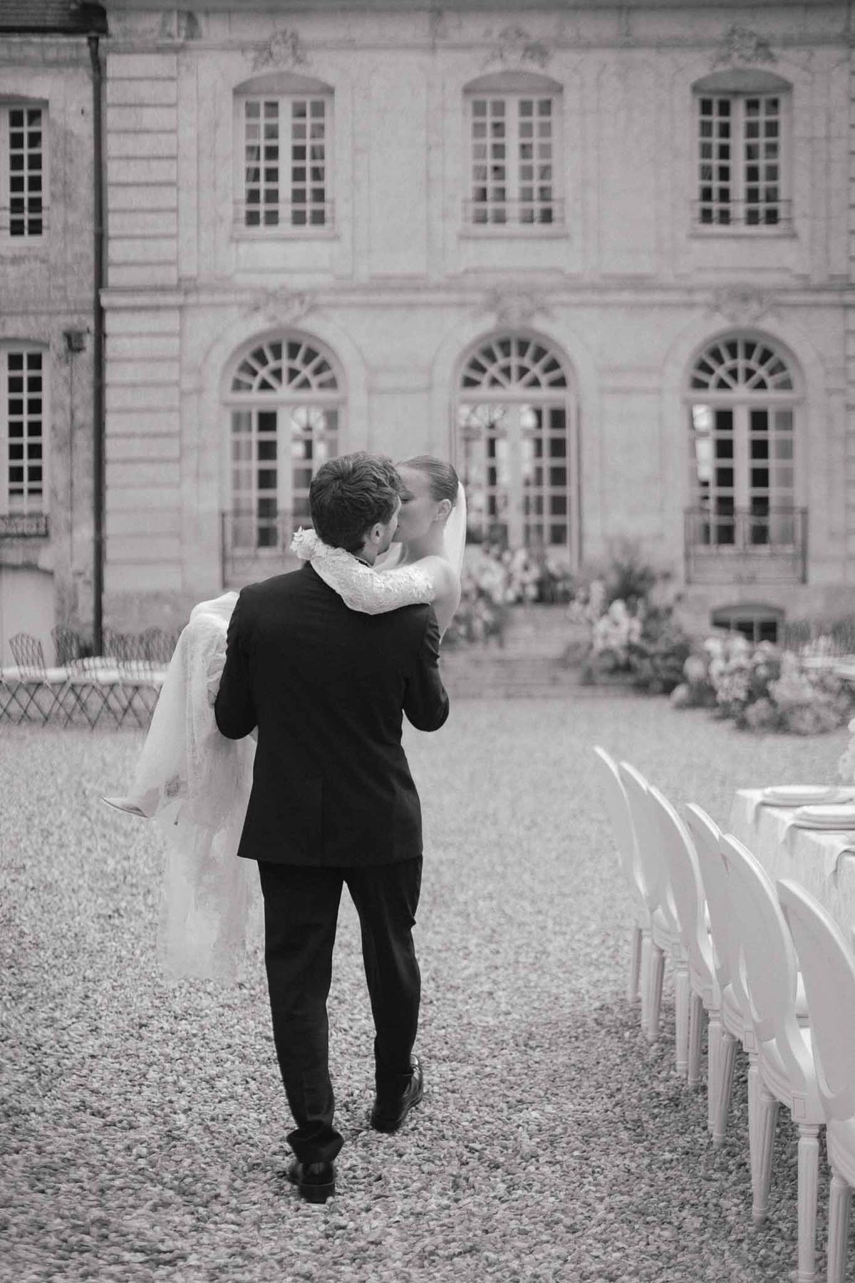 Bride and groom walking together in neoclassical courtyard with elegant architecture