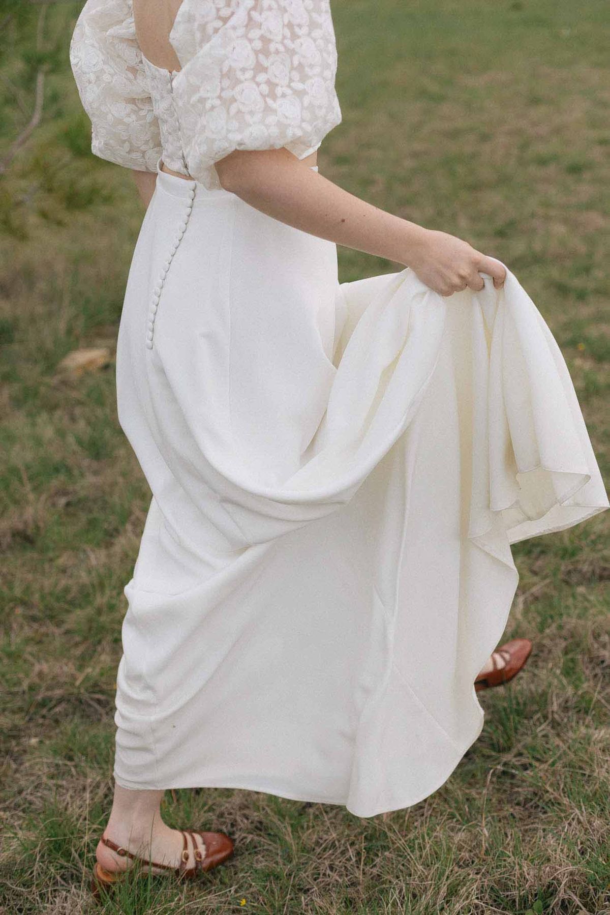 Bride showing wedding dress silhouette in outdoor garden setting