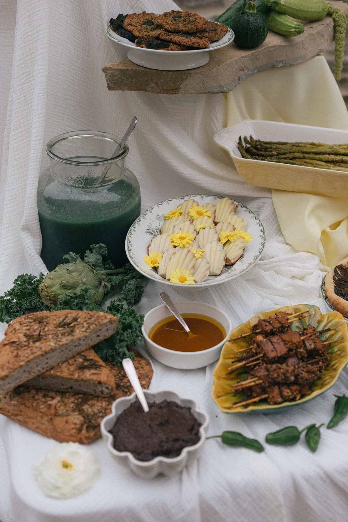 Farm-to-table wedding reception food display with organic vegetables and artisanal dishes on white linens