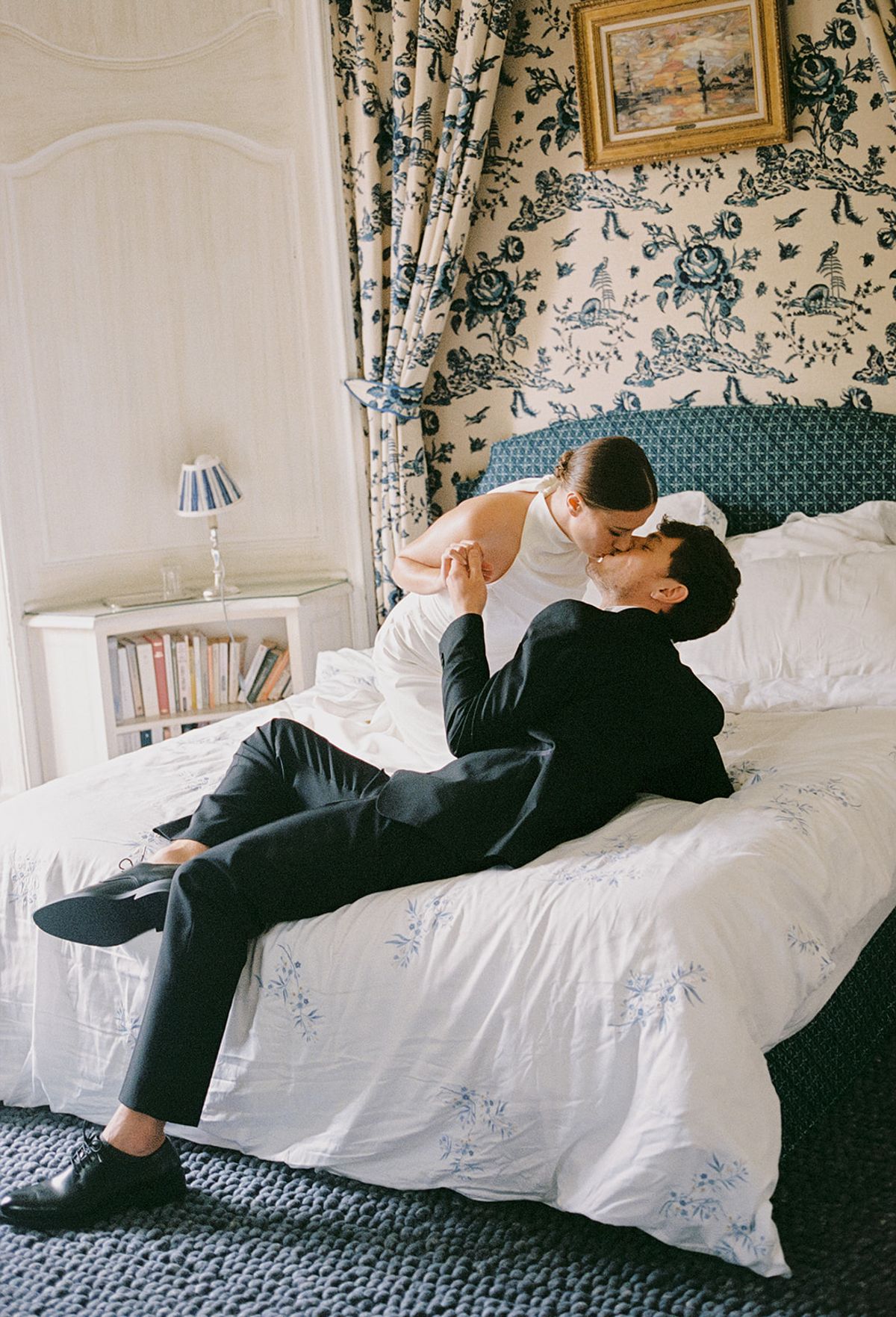 Bride and groom sharing intimate moment in French-style bedroom during wedding day preparations