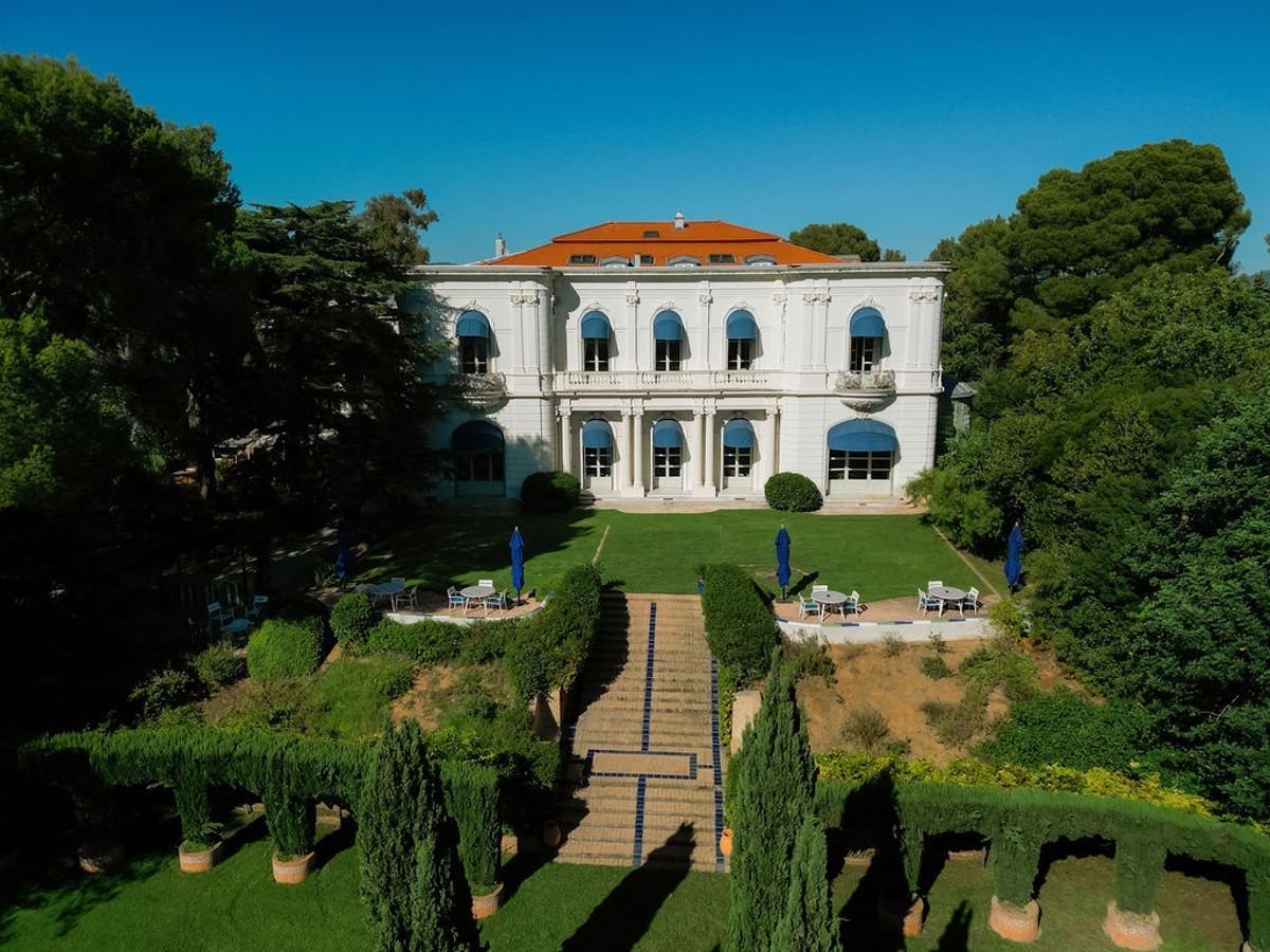 Aerial view of villa facade with formal terraced gardens and stone steps at Domaine Rocabella, French Riviera