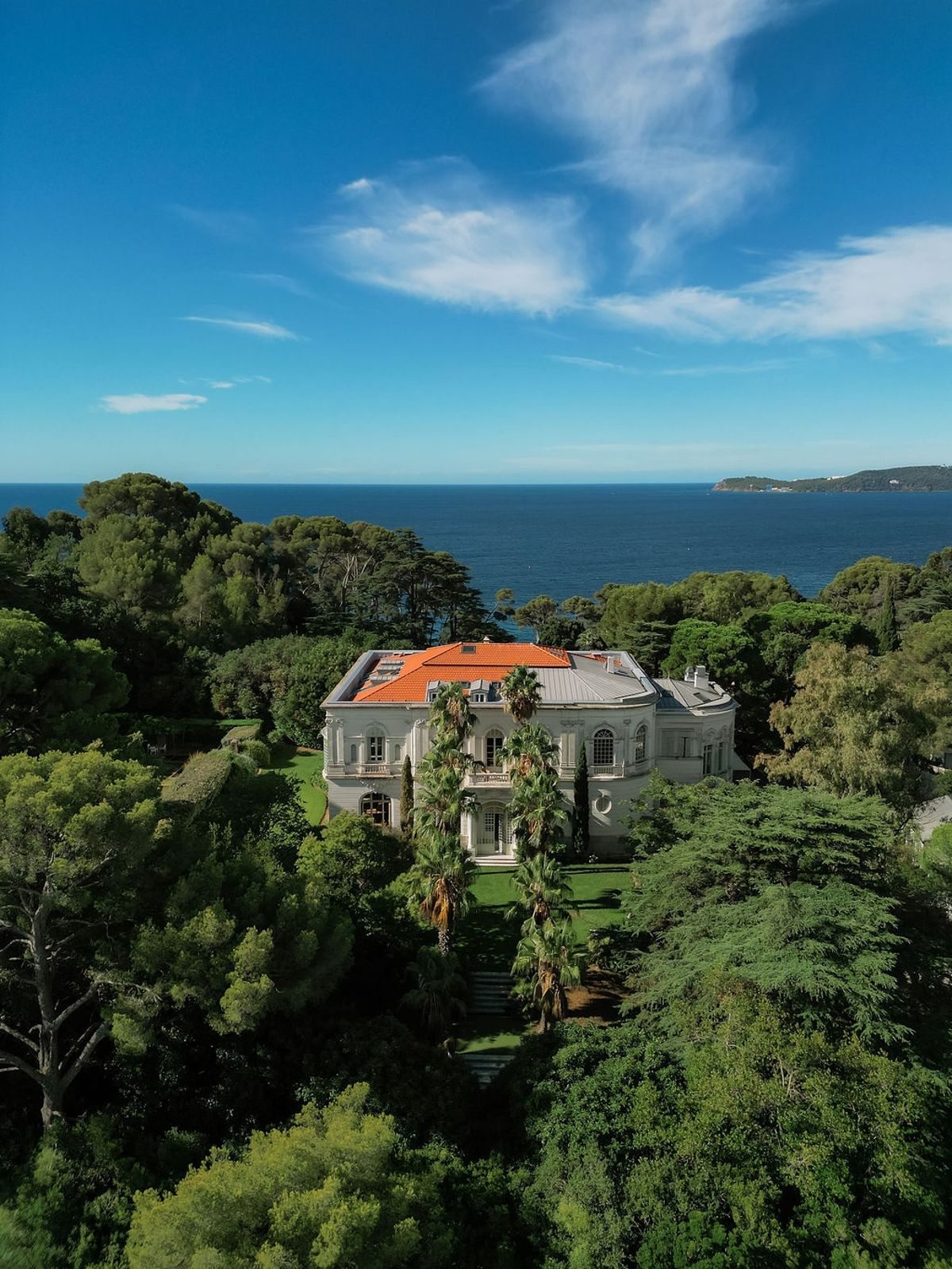 Aerial portrait of Belle Epoque villa among pines with sea horizon at Domaine Rocabella, French Riviera
