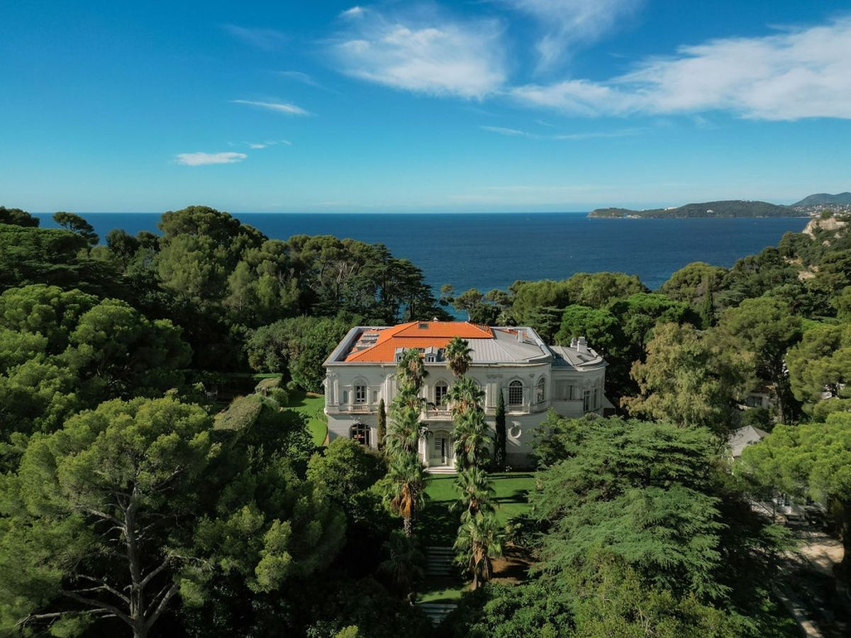 Aerial view of Belle Epoque villa with Mediterranean sea and islands beyond at Domaine Rocabella, French Riviera