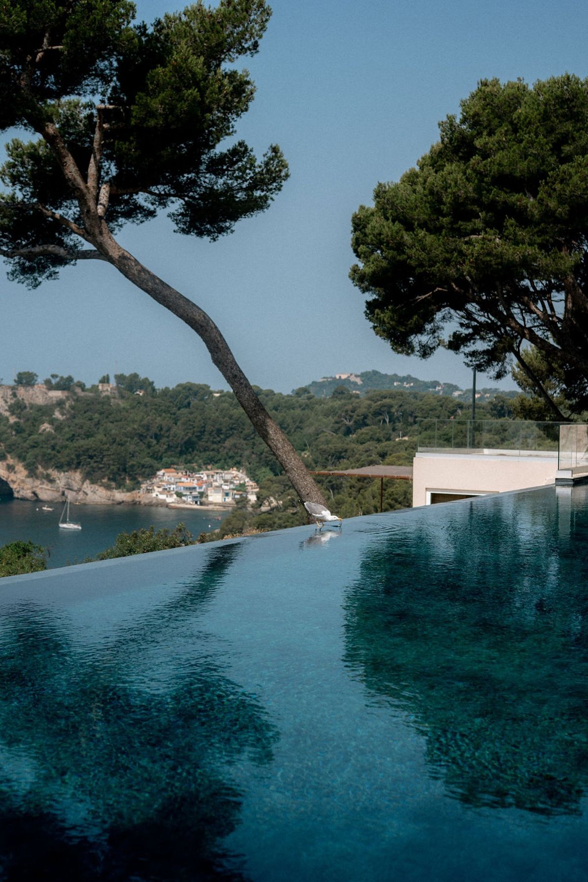 Infinity pool overlooking a cove and coastal village at Domaine Rocabella, French Riviera