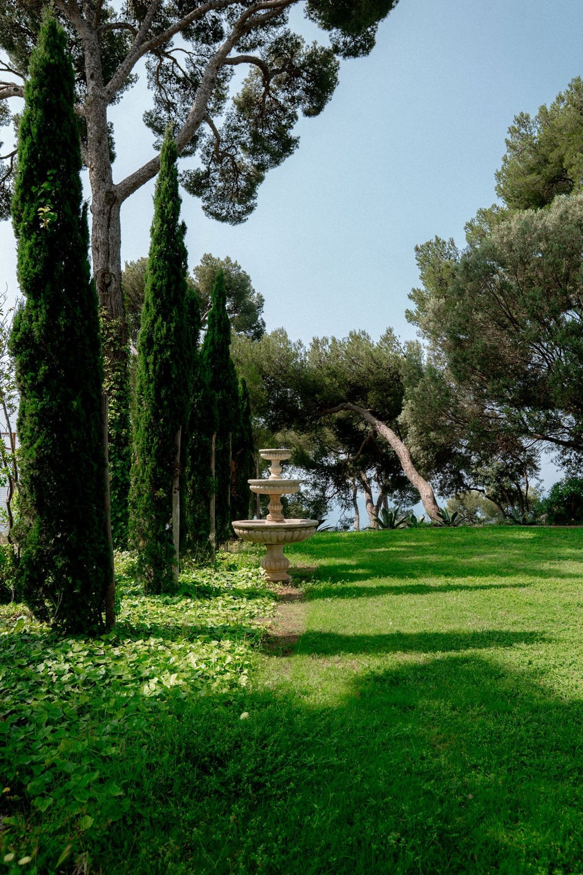 Italian garden with cypress trees and stone fountain at Domaine Rocabella, French Riviera