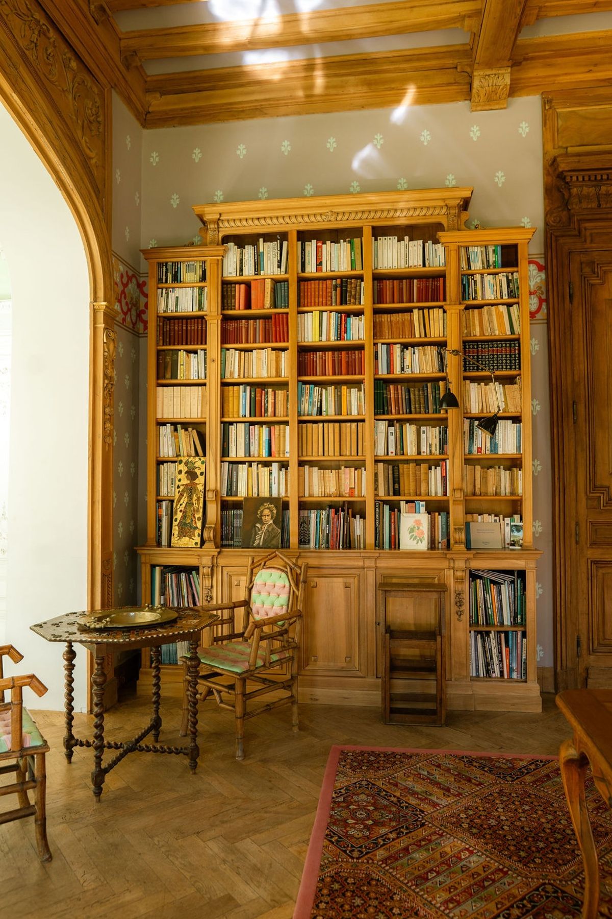 Library with antique bookshelves and timber ceiling at Domaine Rocabella, French Riviera