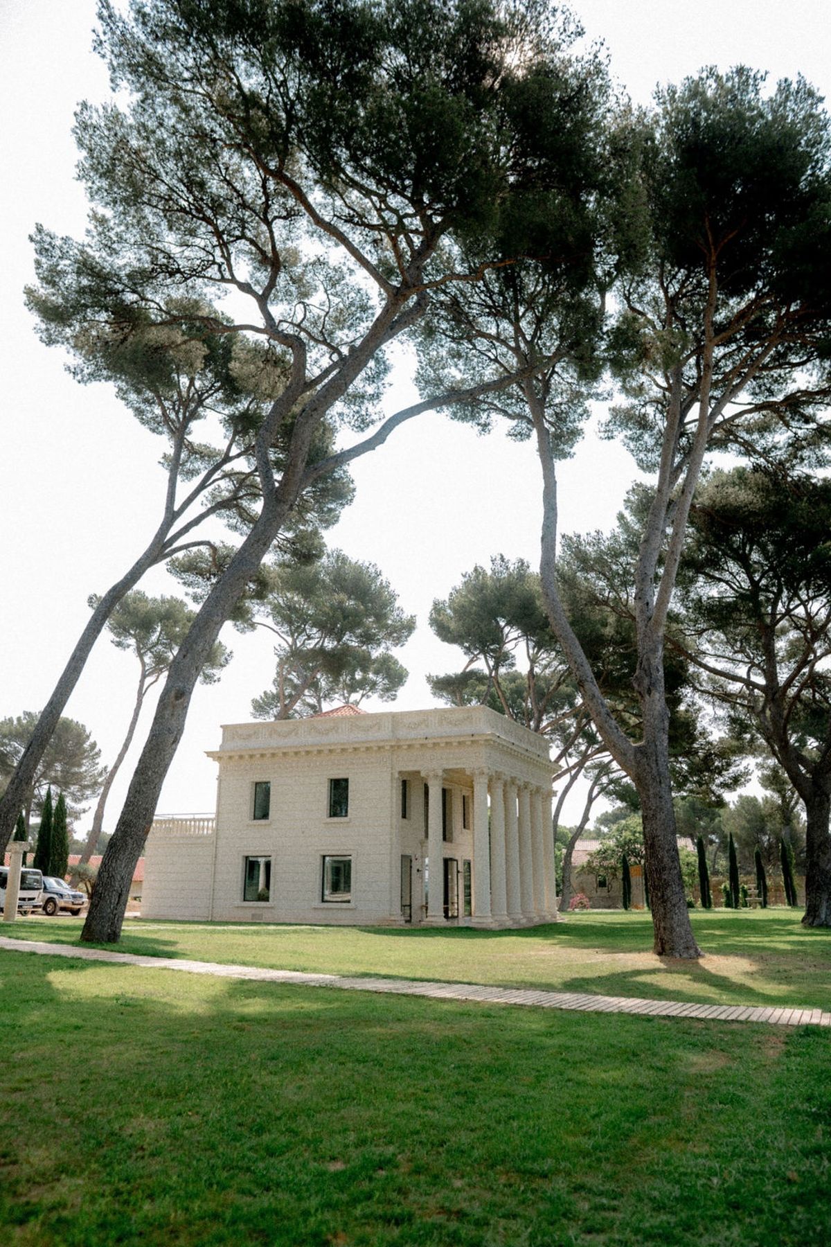Neoclassical villa with columned portico among pine trees at Domaine Rocabella, French Riviera