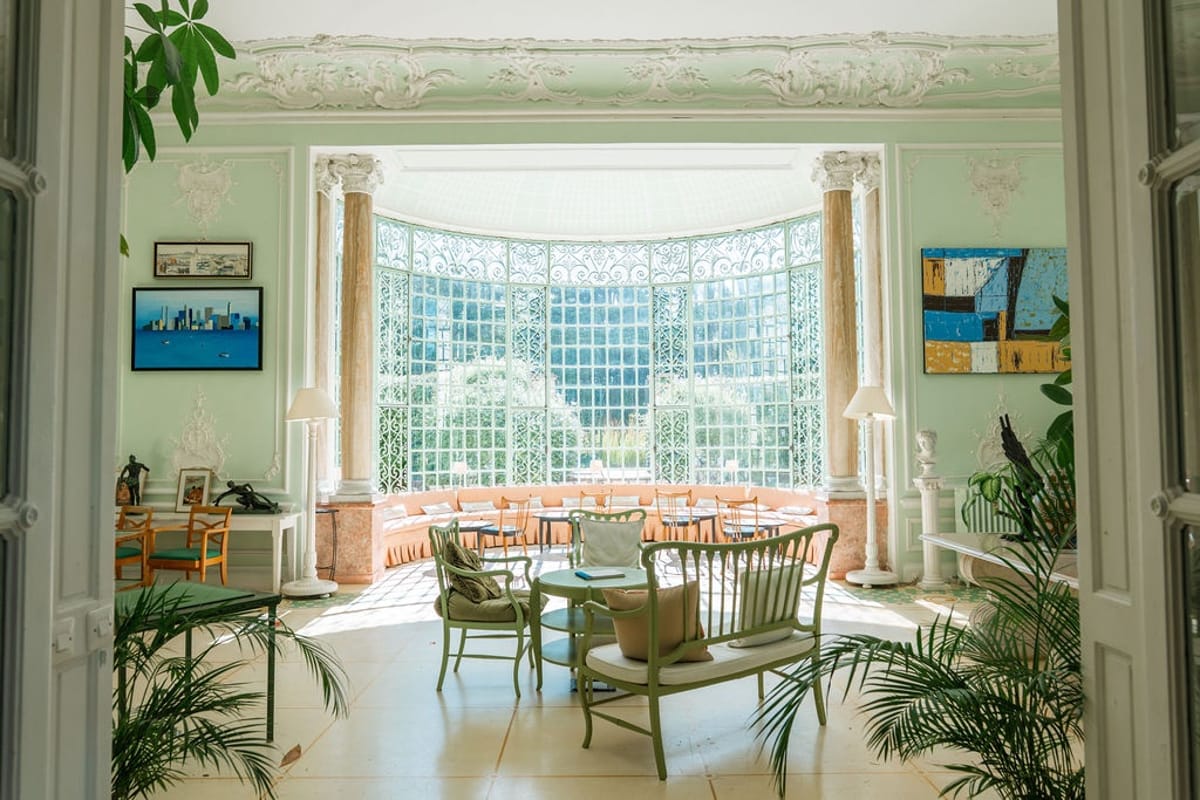 Conservatory salon with garden views and marble columns at Domaine Rocabella, French Riviera