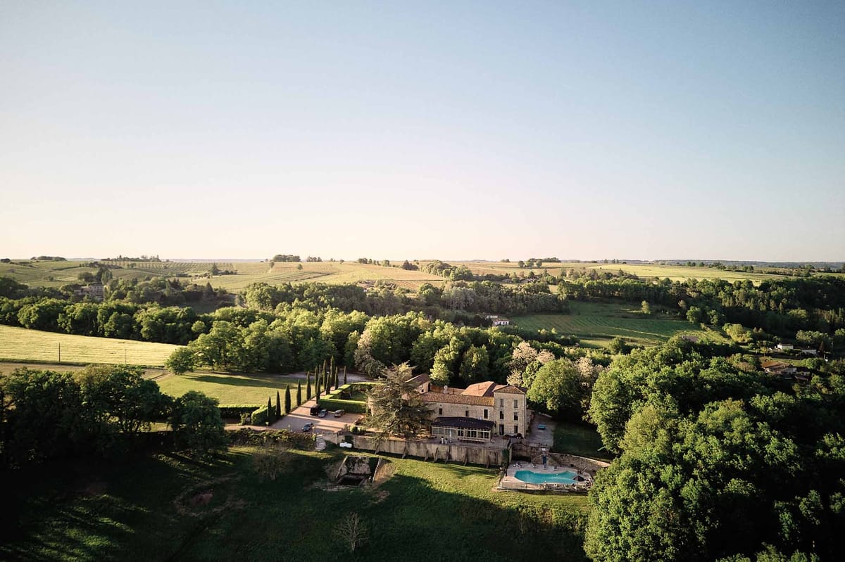 Aerial overlooking pool terrace and Gironde hills at Chateau de Sanse