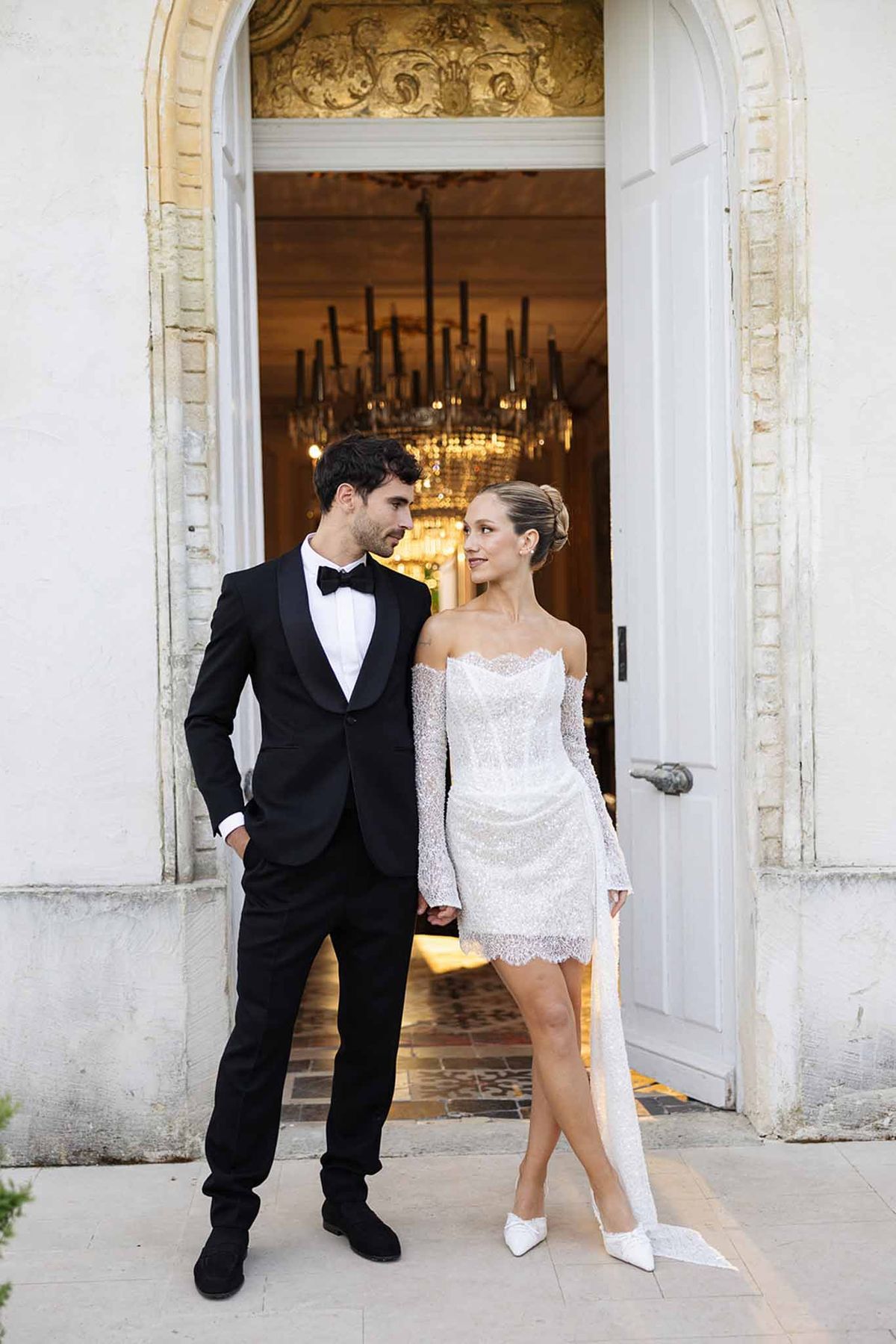 Bride and groom in elegant doorway entrance at neoclassical wedding venue